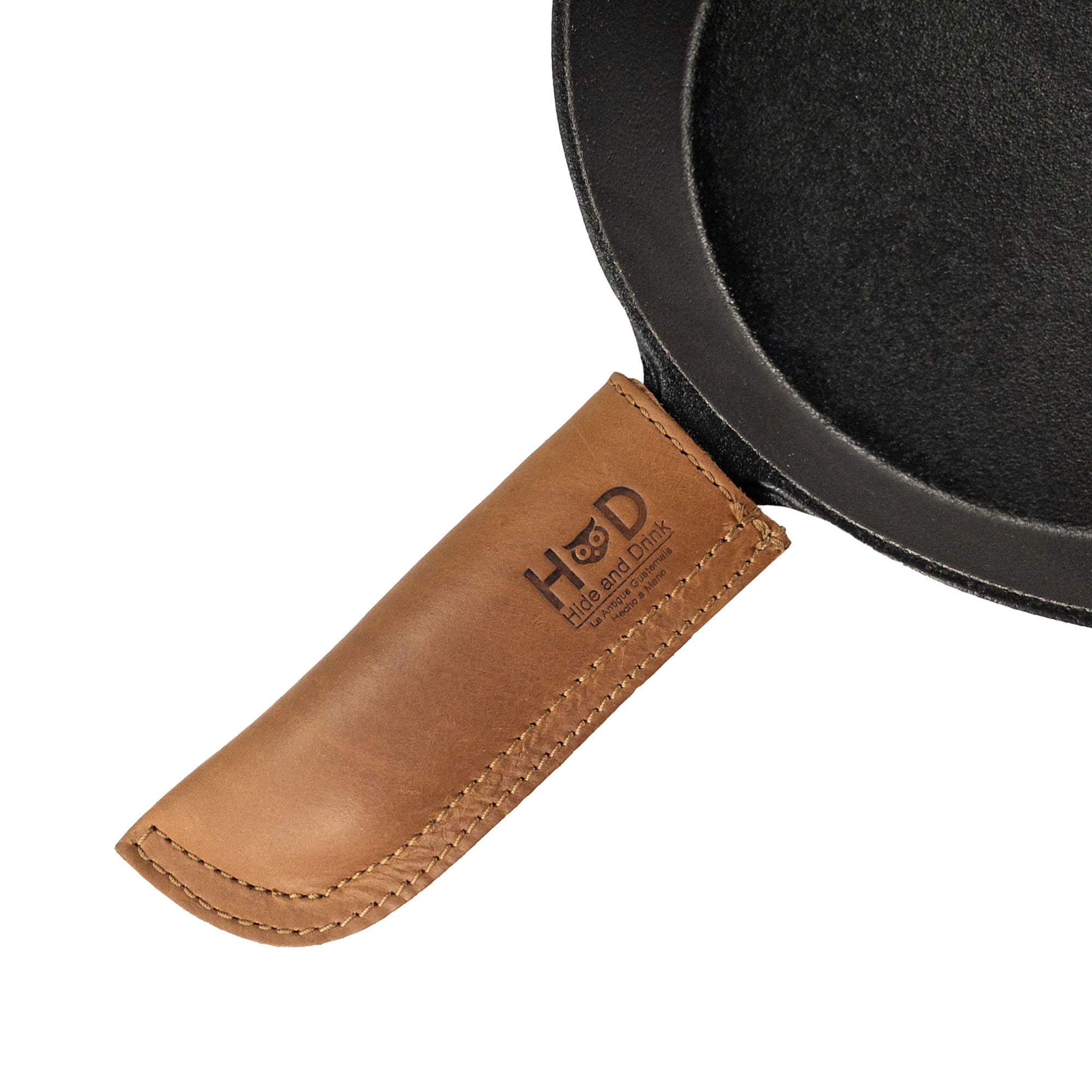 Hide & Drink Cast Iron Panhandle Cover elegantly modeled on a skillet. This artisan piece serves as a hot handle protector, made from durable full grain leather and features double stitched craftsmanship. Hand cut and sewn in La Antigua Guatemala & Oaxaca Mexico, it enhances kitchen safety and style.