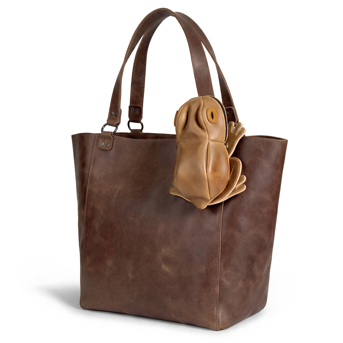 Tudi Frudi Frog Pouch attached to a brown leather tote, showcasing a Frog-Shaped Pouch made as a Cable Organizer and Small Accessory Case; a Zippered Cash Holder Wallet for Coins and Change Purse for Pouches for Men and Women, crafted from Full Grain Leather by StockyardX through Small Batch Production, Hand Cut, Hand Sewn, Fire Branded, Artisan, Handmade in La Antigua Guatemala & Oaxaca Mexico.