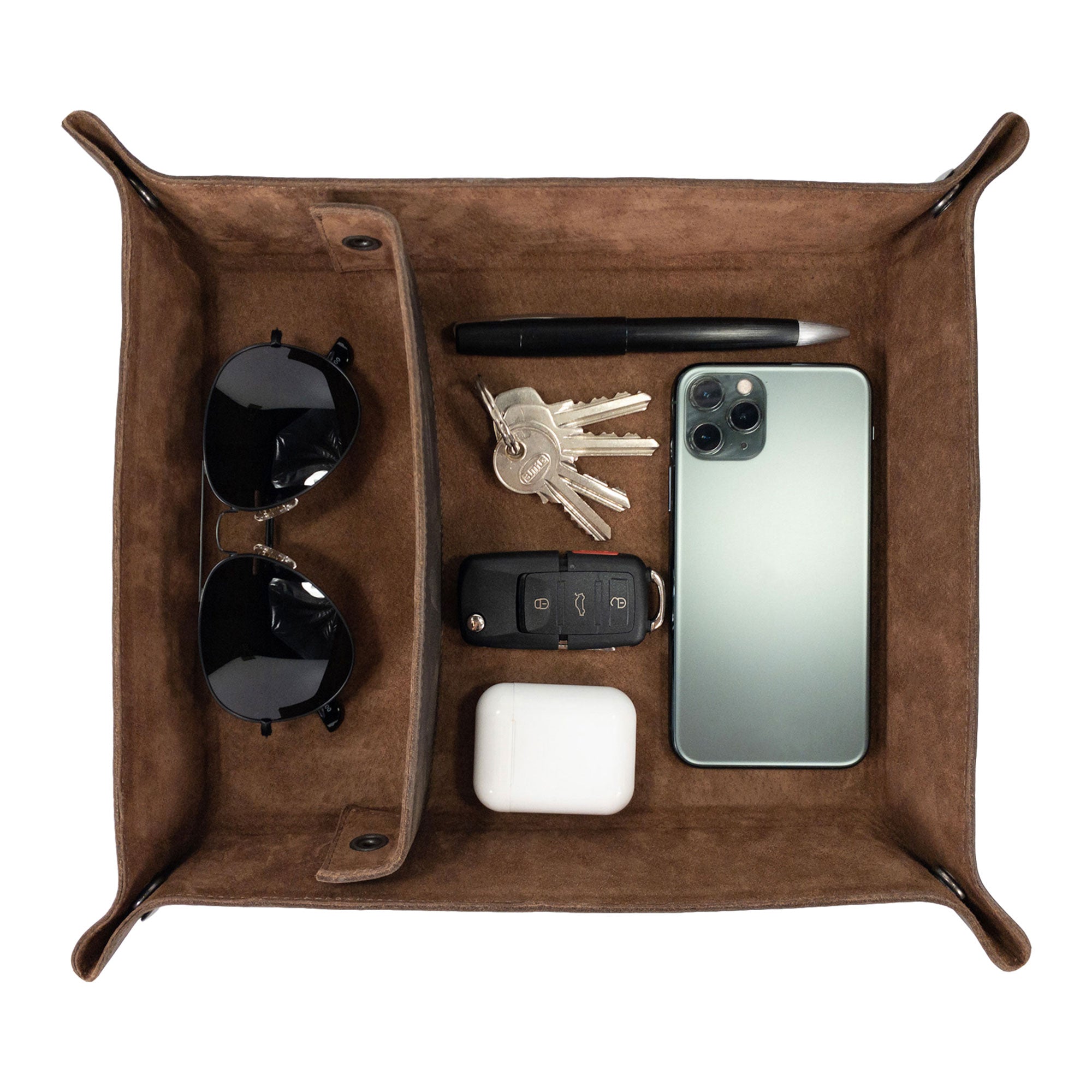A stylish Rectangular Catchall with Removable Compartment by Hide & Drink featuring sunglasses, keys, a phone, and a pen inside. This desktop storage solution is crafted from Full Grain Leather & Sheepskin, showcasing the quality of artisan work. Ideal for organization, this handmade product reflects Small Batch Production, Hand Cut, Hand Sewn, Fire Branded techniques, made in La Antigua Guatemala & Oaxaca Mexico.