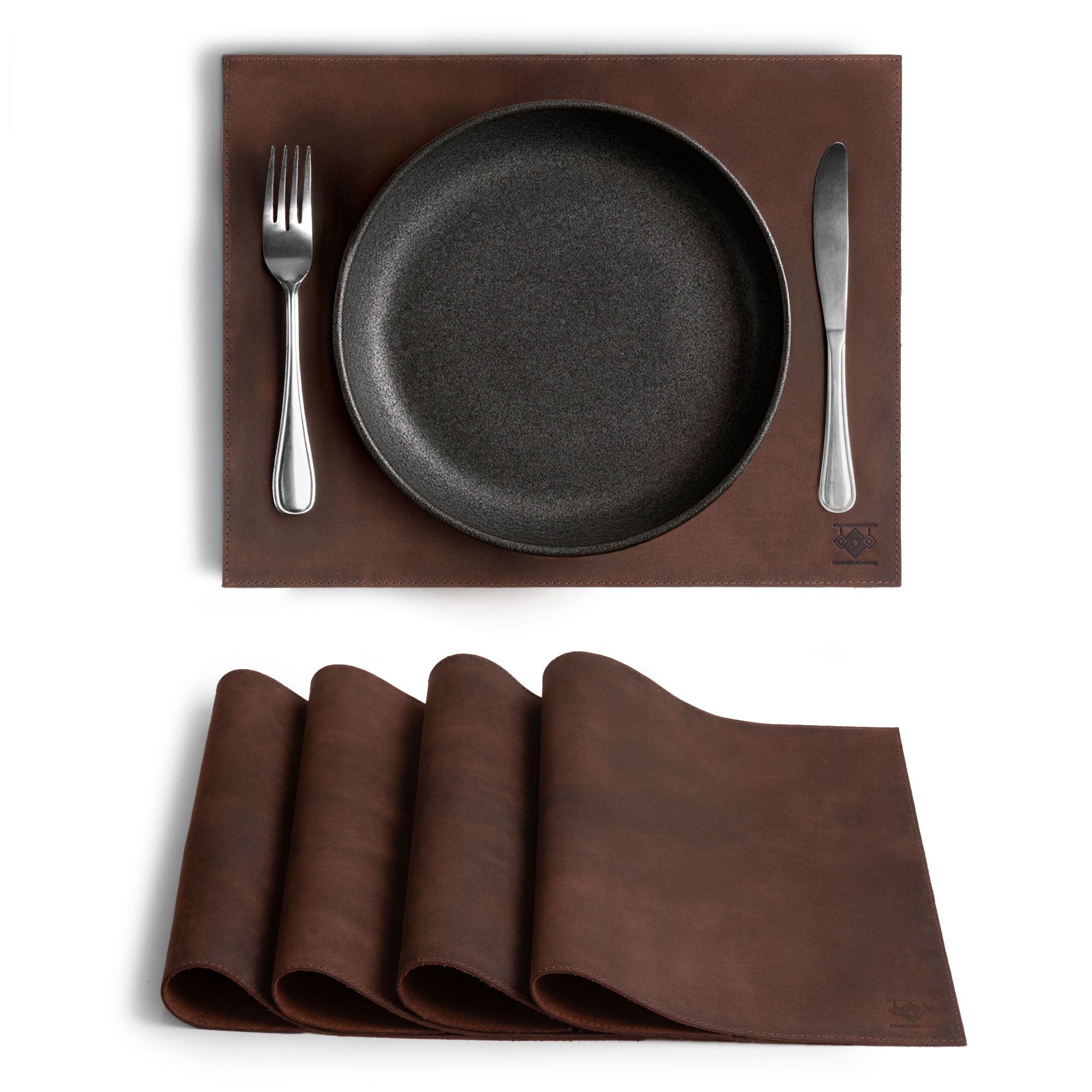 Set of 4 Rectangular Place Mats from Leather At Home, showcasing genuine placemats made from full grain leather. These rustic mats feature a stylish design with a plate and cutlery setup, highlighting artisan craftsmanship from La Antigua Guatemala & Oaxaca Mexico.