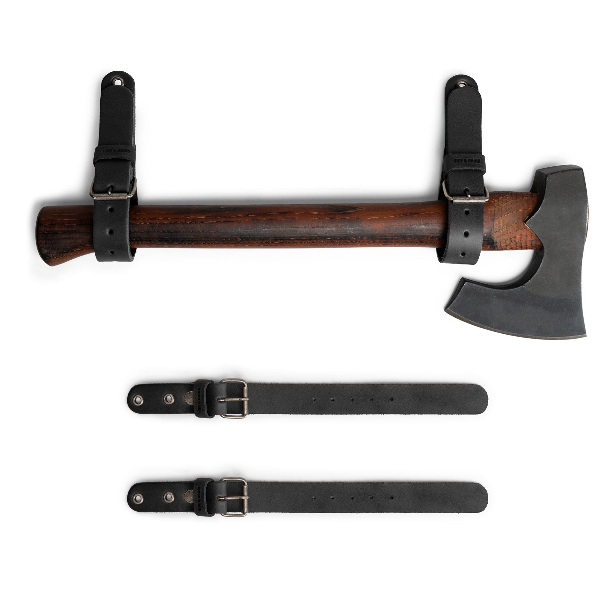 Hide & Drink Wall Hanging Strap in a black leather variant, demonstrating its robust design with an axe mounted. This set of 2 heavy-duty tool hangers is perfect for garage storage and organization, featuring a buckle closure for axes, hatchets & tools. The straps are created from full grain leather, emphasizing the artisan hand-cut, hand-sewn quality from La Antigua Guatemala & Oaxaca Mexico.