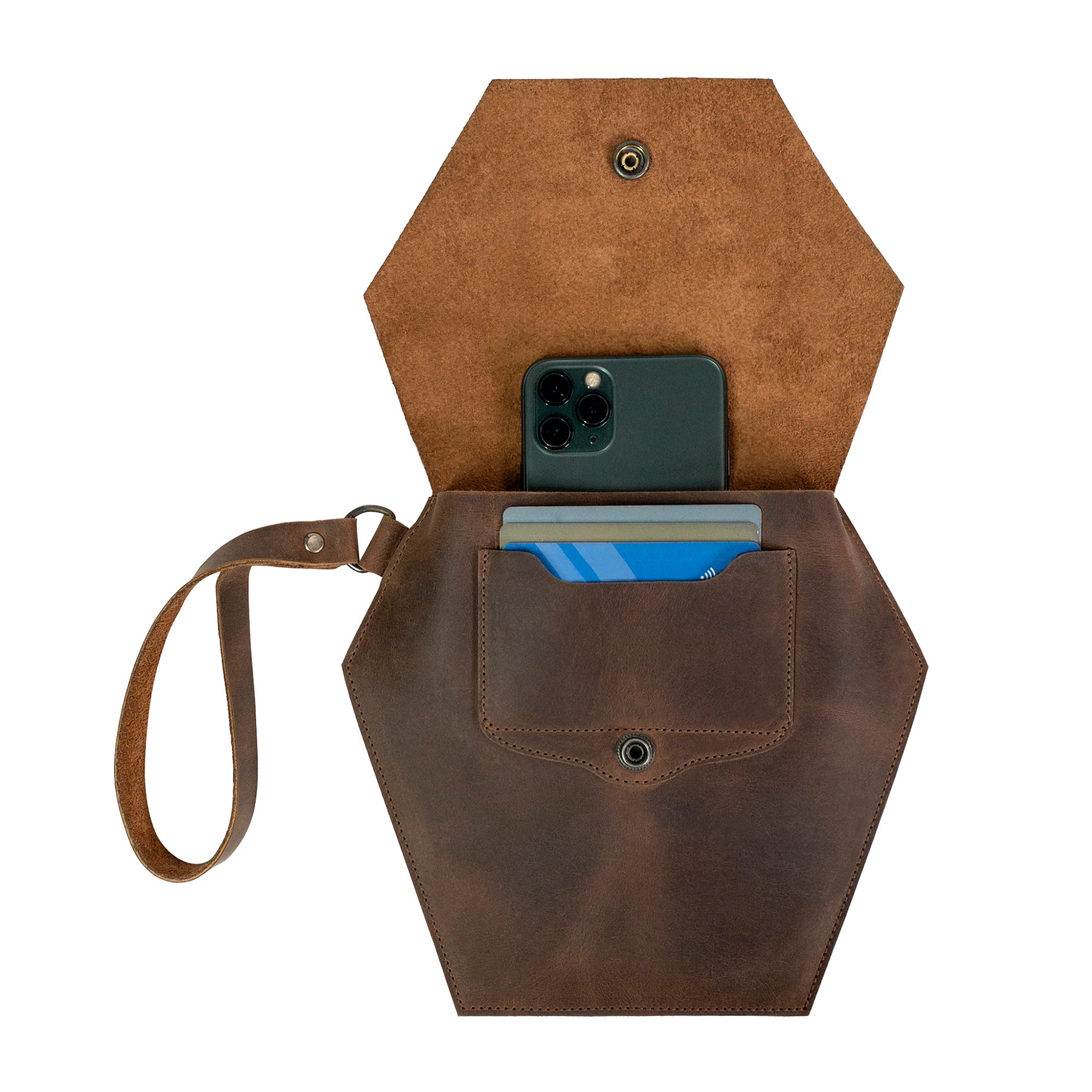 Inside view of Heather's Hexagonal Clutch Bag, showing an iPhone and cards stored comfortably. This elegant travel handbag for women is designed from premium Full Grain Leather, making it ideal for makeup and toiletry items. Each bag is a product of small batch production, handcrafted in La Antigua Guatemala & Oaxaca Mexico.