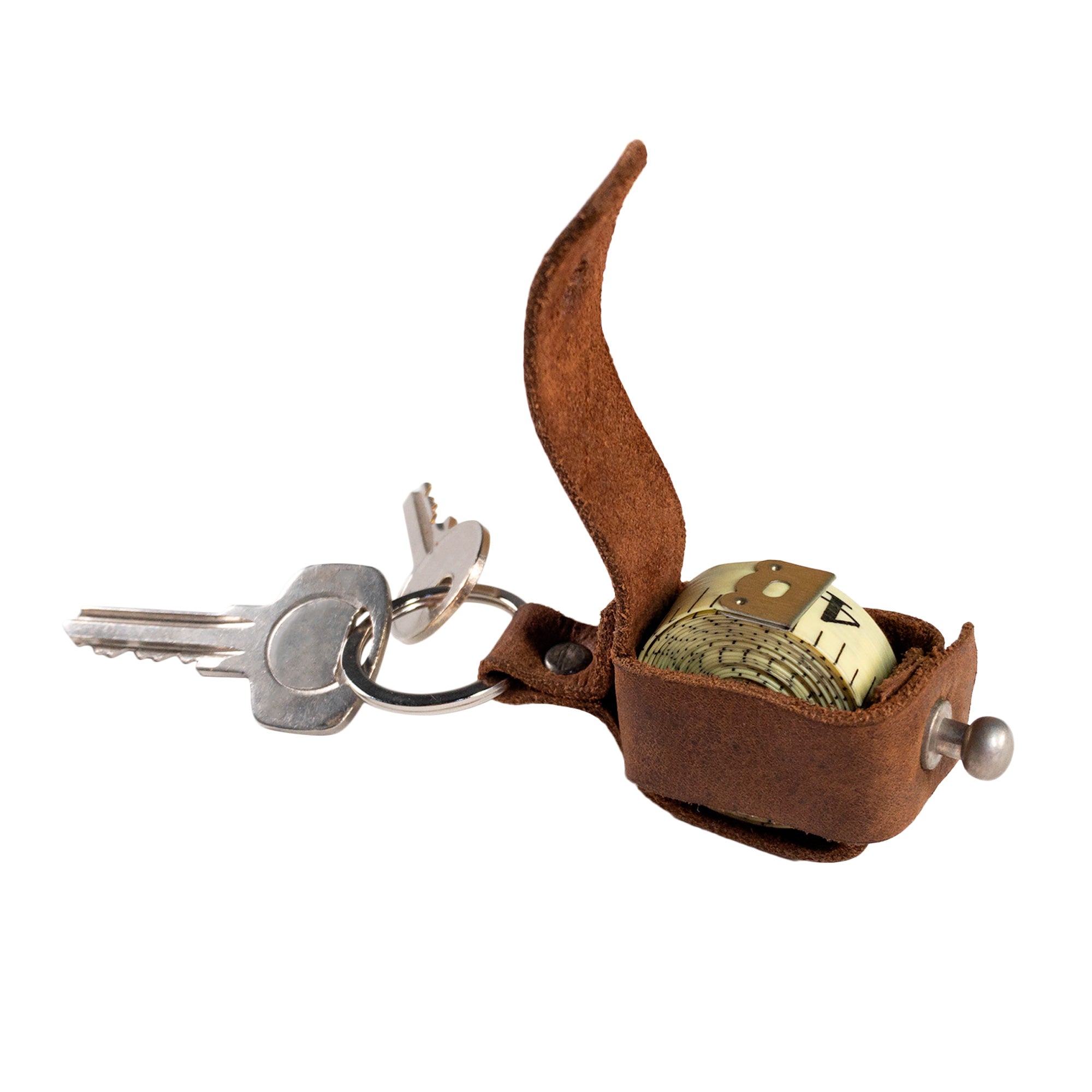 Close-up of the Hide & Drink Measuring Tape Holder Keychain, showcasing the measuring tape tucked neatly and securely on a key ring organizer. This chic accessory keeps your measuring tape (Tape not Included) organized, made of durable Full Grain Leather. An excellent choice for tailor accessories highlighting artisan, small batch production, and hand crafted quality from La Antigua Guatemala & Oaxaca Mexico.