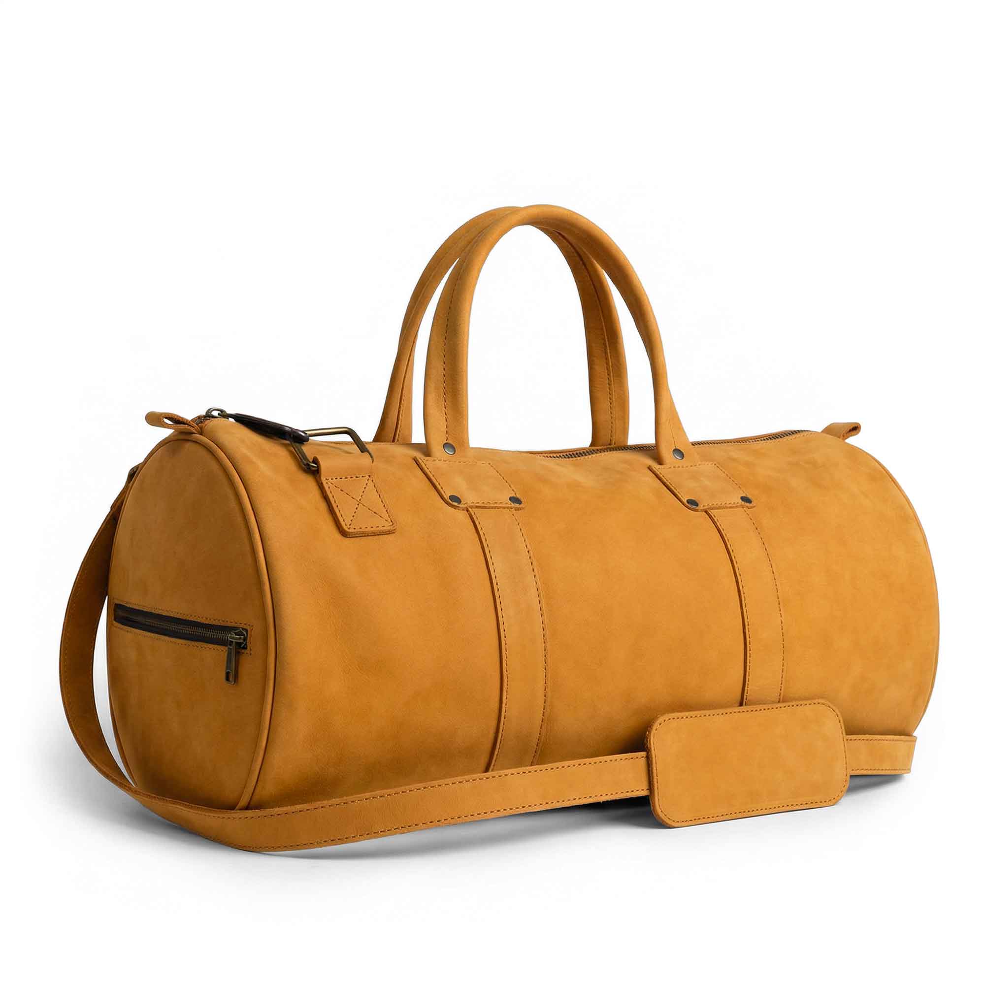 Classic Duffle Bag by Hide & Drink in orange suede leather, featuring an adjustable strap and zipper closure for travel convenience. This versatile Full Grain Leather Classic Duffle Bag makes an excellent Messenger Bag, crafted by artisans in La Antigua Guatemala & Oaxaca Mexico.