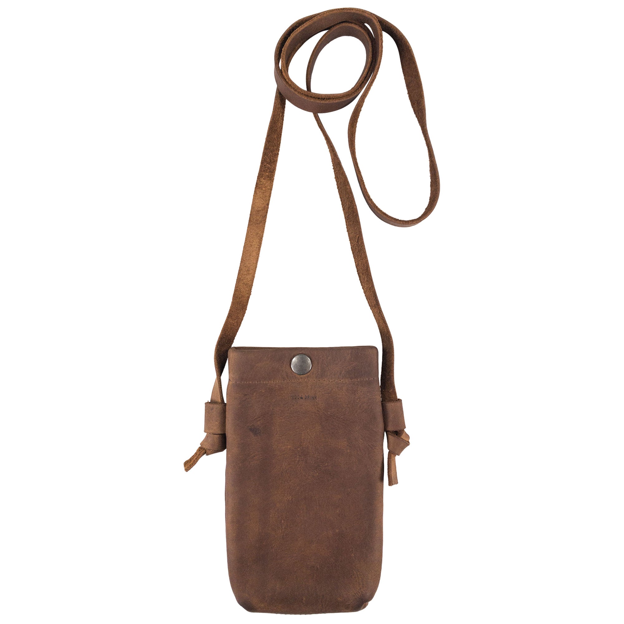 Hide & Drink Cell Phone Shoulder Bag presented in a rustic style, made of durable full grain leather. This phone bag features a soft exterior and a strap for easy carrying. Ideal as a shoulder bag or crossbody bag for cellphone use, it serves as a thoughtful travel accessory with handmade quality from artisans in La Antigua Guatemala & Oaxaca Mexico.
