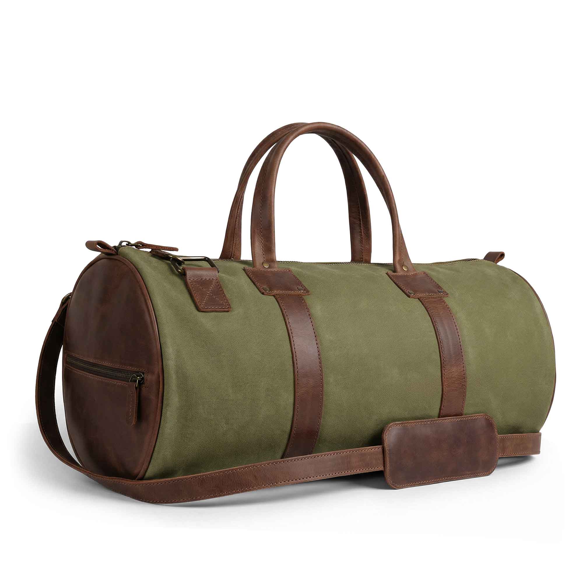 Side view of the Classic Duffle Bag by Hide & Drink in green with leather accents. This Full Grain Leather Classic Duffle Bag includes an adjustable strap and zipper closure, making it a perfect Messenger Bag for trips, handmade in La Antigua Guatemala & Oaxaca Mexico.