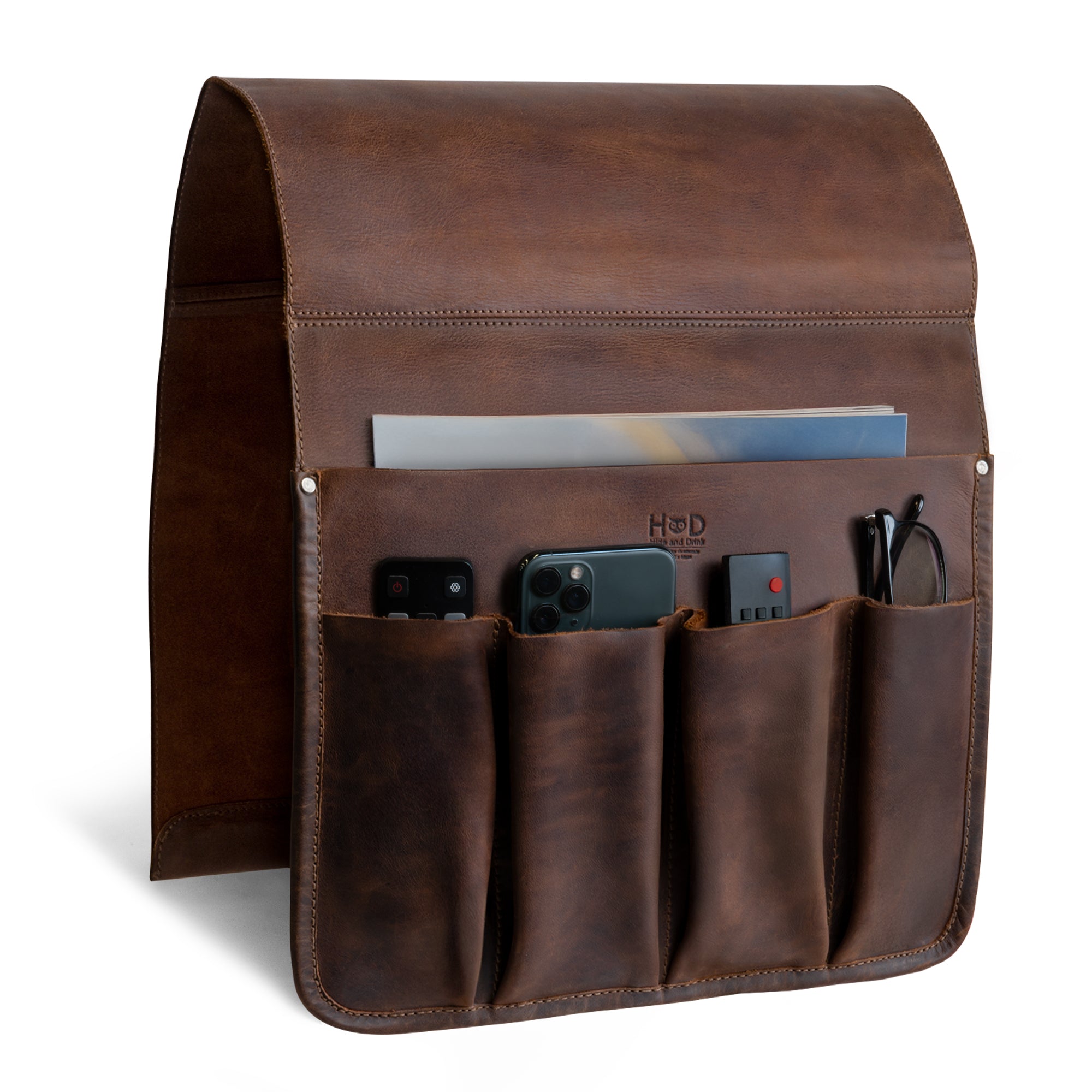 Hide & Drink Remote Control Holder made from full grain leather, showcasing its rustic design with multiple pockets perfect for organizing remotes and magazines. Ideal as a sofa armrest organizer pouch, this couch potato essential is artisan-crafted in La Antigua Guatemala.