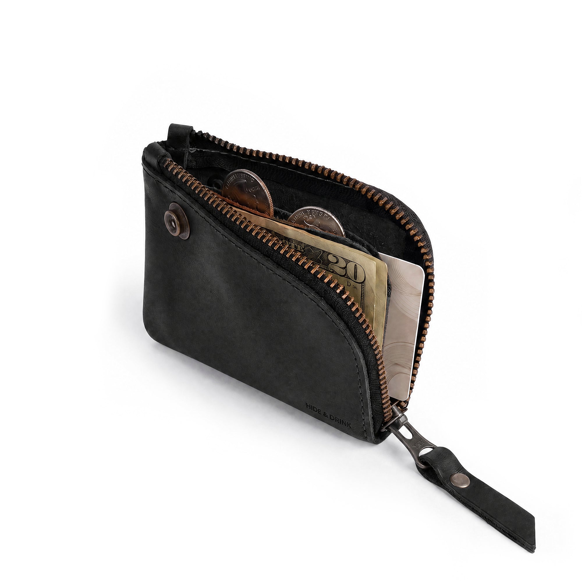 Interior view of the black Lion's Mane Zippered Wallet by Hide & Drink filled with coins and cards, illustrating its practical design as a pocket-size organizer.