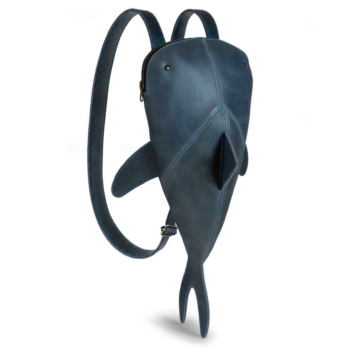 Hide & Drink Leather Shark Backpack (Megalodon) shown from the side with shark fin details, adjustable straps, and tail design. Leather Shark Backpack (Megalodon), Casual Bag, Messenger Bag, Travel Bag for Men and Women, Full Grain Leather, StockyardX, Small Batch Production, Hand Cut, Hand Sewn, Fire Branded, Artisan, Handmade in La Antigua Guatemala & Oaxaca Mexico.