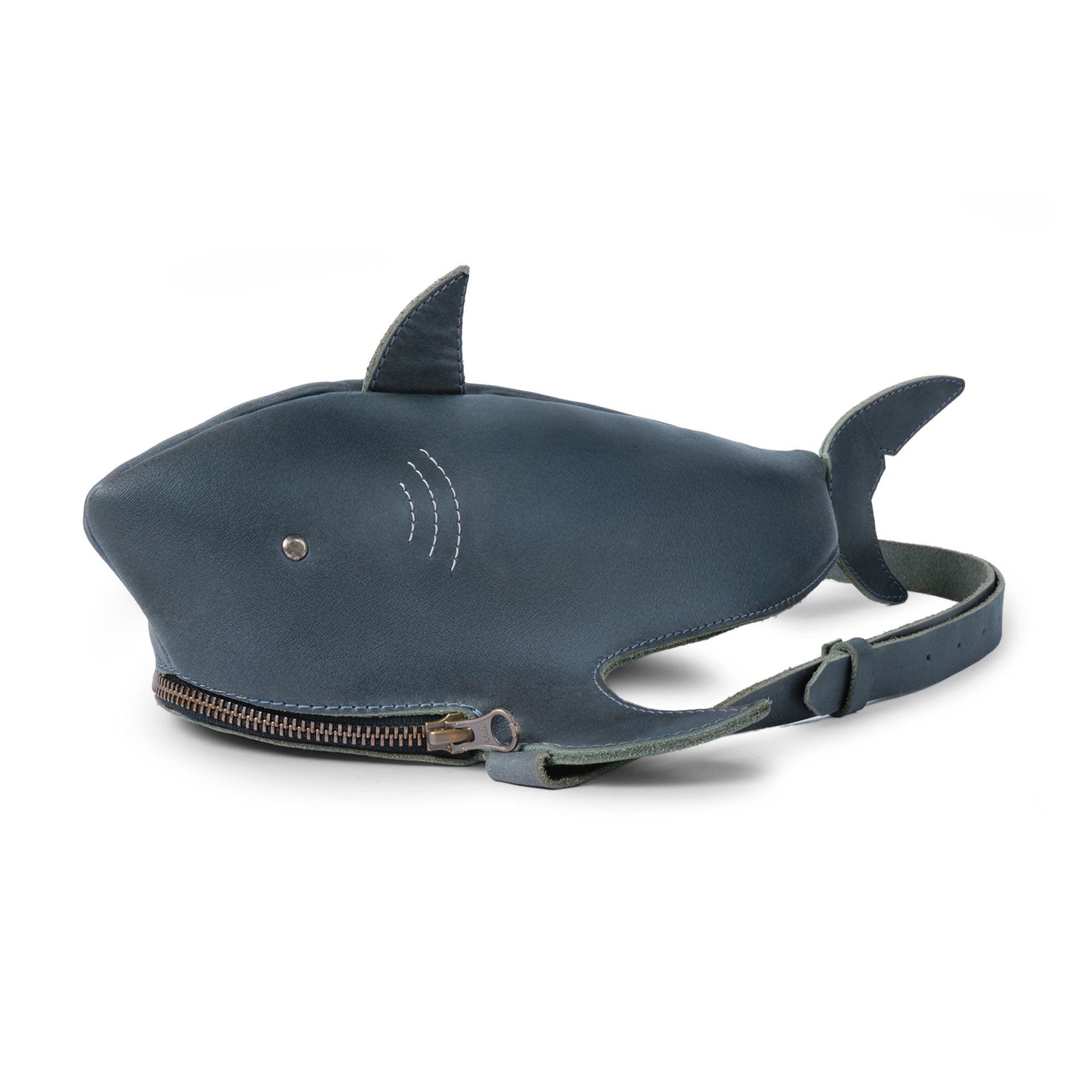 Tudi Frudi's Shark-Shaped Shoulder Bag showcases a unique shark design in full grain leather, featuring an adjustable strap for versatility as a Crossbody Shoulder Messenger Bag. Perfect for travel, this artisan-crafted piece is hand cut and sewn, highlighting the beauty of handmade in La Antigua Guatemala.