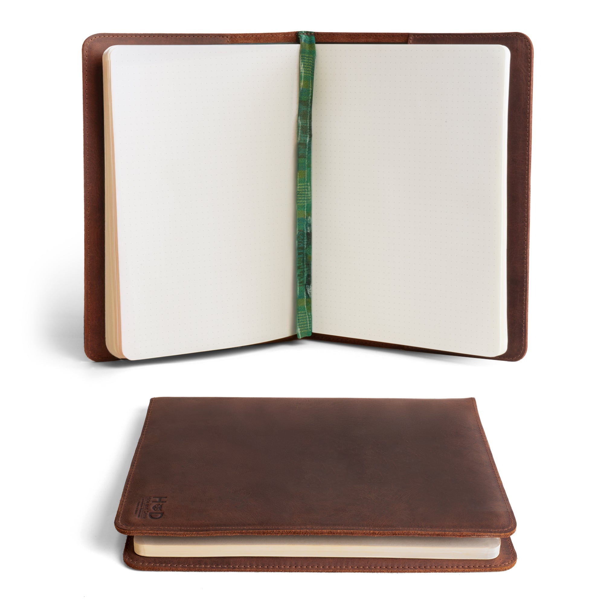 Open view of the Full Grain Leather Journal Cover for Moleskine Cahier XL (7.5 x 9.75 in.) by Hide & Drink. This stylish notebook case features a handmade finish with a cozy green bookmark, perfect for personalized journaling. Ideal for any writing enthusiast, this case showcases small batch production with hand cut and sewn details, ensuring quality craftsmanship through artisan efforts in La Antigua Guatemala & Oaxaca Mexico.