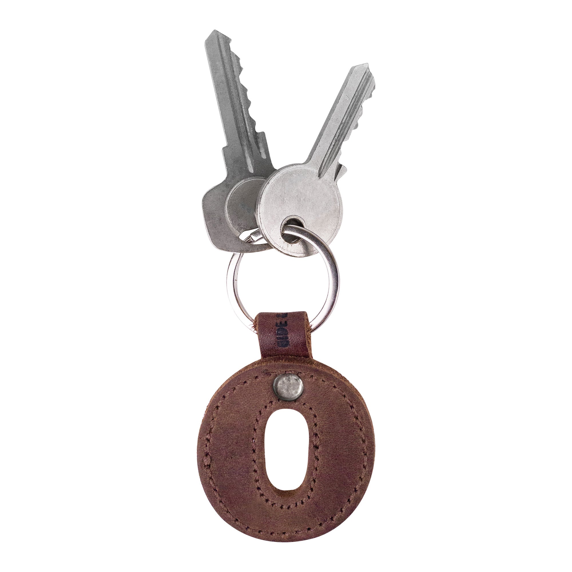 Stylish Alphabet Letter Keychain featuring the letter O, attached to keys. This thick leather accessory by Hide & Drink offers a unique charm with its Full Grain Leather construction and artisan craftsmanship from La Antigua Guatemala.