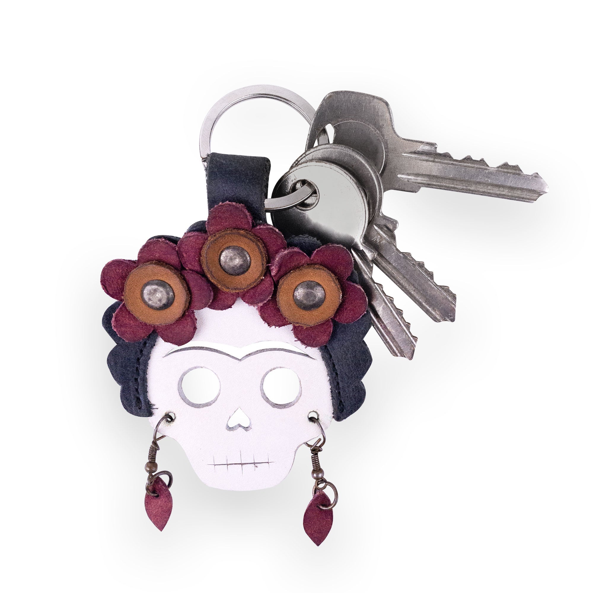 Close-up of the Lady Skull Leather Keychain by Hide & Drink, highlighting the intricate flowers and Day Of The Dead theme. This unique keyring is a stylish key organizer, embodying Mexican culture created from quality Full Grain Leather, hand sewn by artisans in La Antigua Guatemala and Oaxaca Mexico.