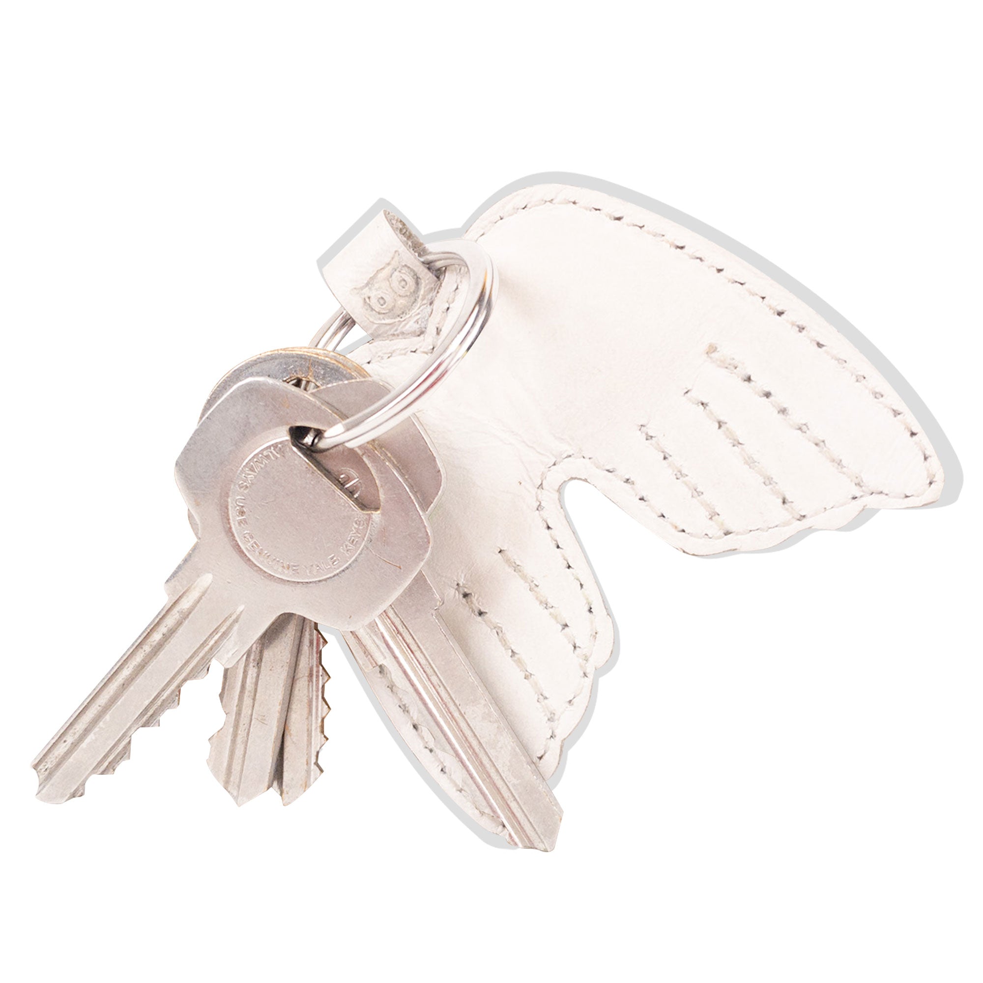 Angel Wings Keychain by Hide & Drink with keys hanging from a beautiful Full Grain Leather design. This elegant key ring holder symbolizes peace, made through small batch production methods. Each piece is handmade in La Antigua Guatemala & Oaxaca Mexico, featuring hand-cut, hand-sewn details and a fire branded finish, representing artisanal quality.