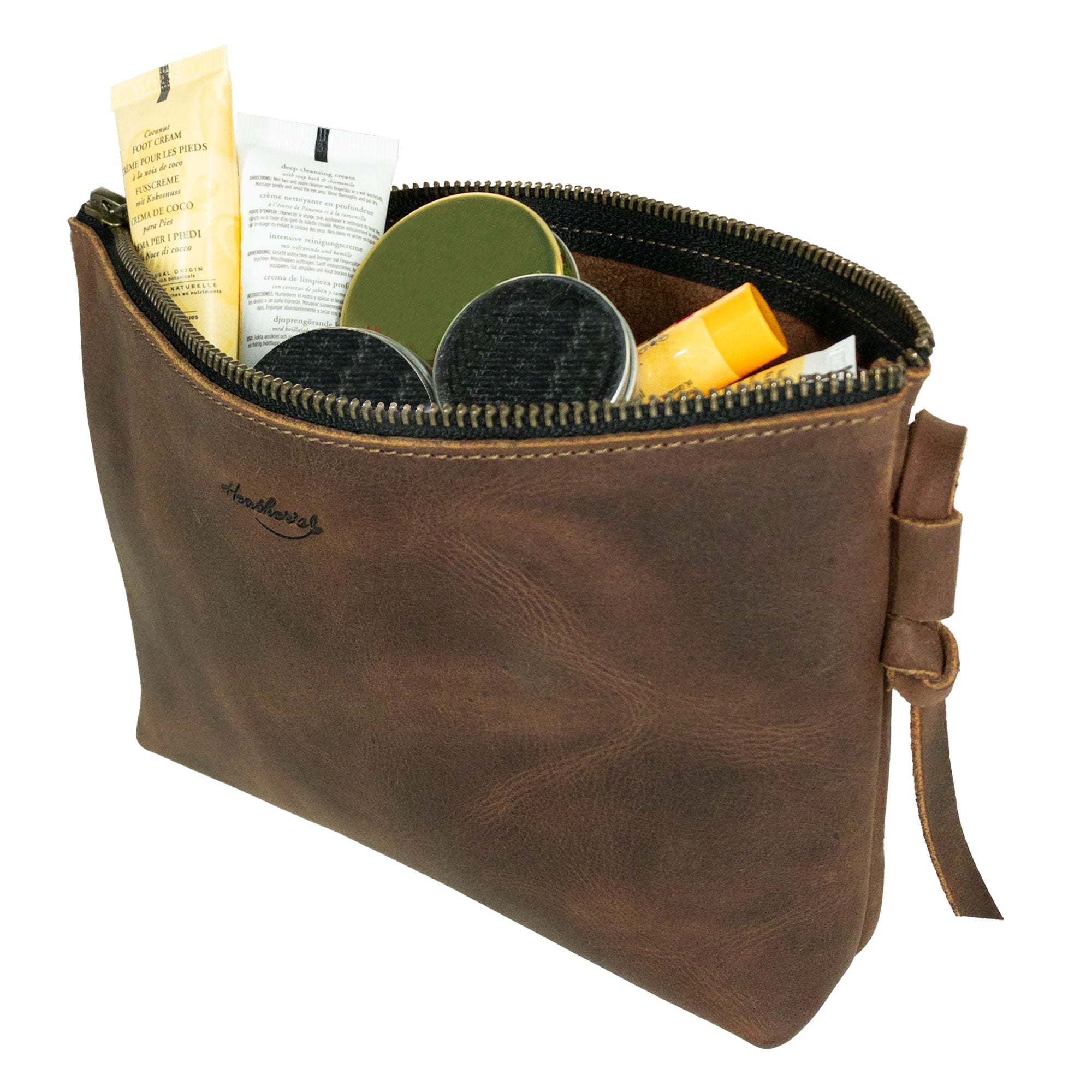 Inside view of Heather's Clutch Bag with Strap, showing its capacity to hold makeup and toiletries. This Full Grain Leather accessory is an essential wrist wallet for cards and money, made with artisan care in La Antigua Guatemala & Oaxaca Mexico, emphasizing small batch production and handcrafted quality.