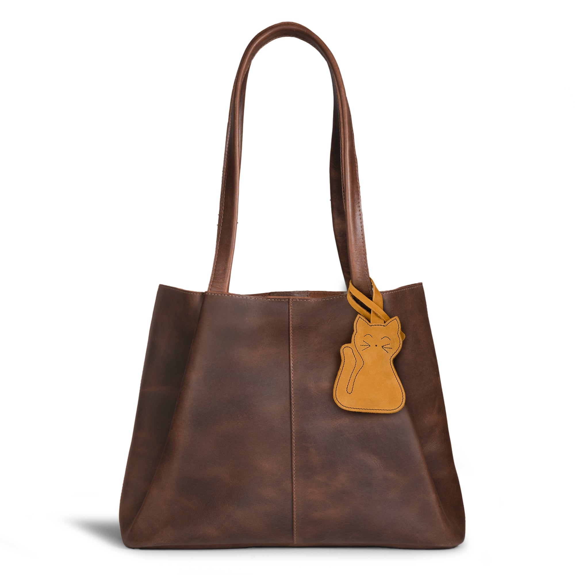 Hide & Drink Bag Charms attached to a brown handbag, highlighting a fun nose design ideal for personalization. This purse charm for tote & backpacks is crafted from full grain leather, reflecting StockyardX's commitment to small batch production. Each piece displays meticulous hand cut, hand sewn craftsmanship and fire branding, handmade in La Antigua Guatemala & Oaxaca Mexico.