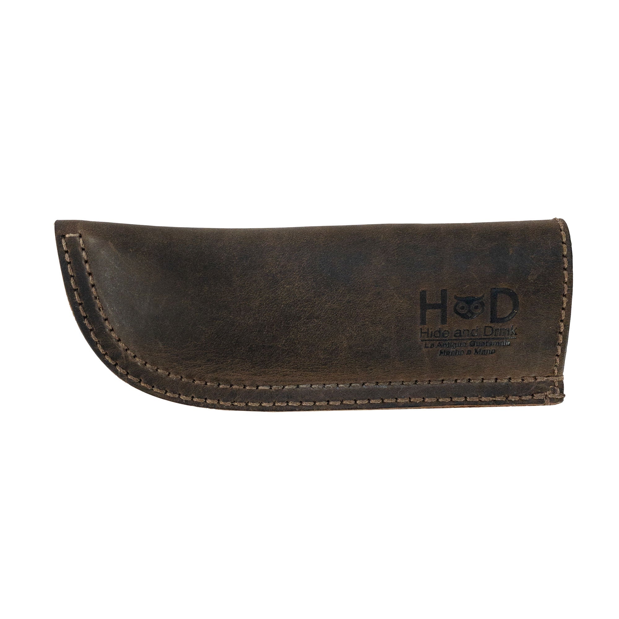 Hide & Drink Cast Iron Panhandle Cover dramatically displayed, emphasizing its unique design. This artisan hot handle protector blends full grain leather craftsmanship with practicality, featuring double stitching for durability. Handmade in La Antigua Guatemala & Oaxaca Mexico, it's perfect for adding a stylish touch to your cooking.