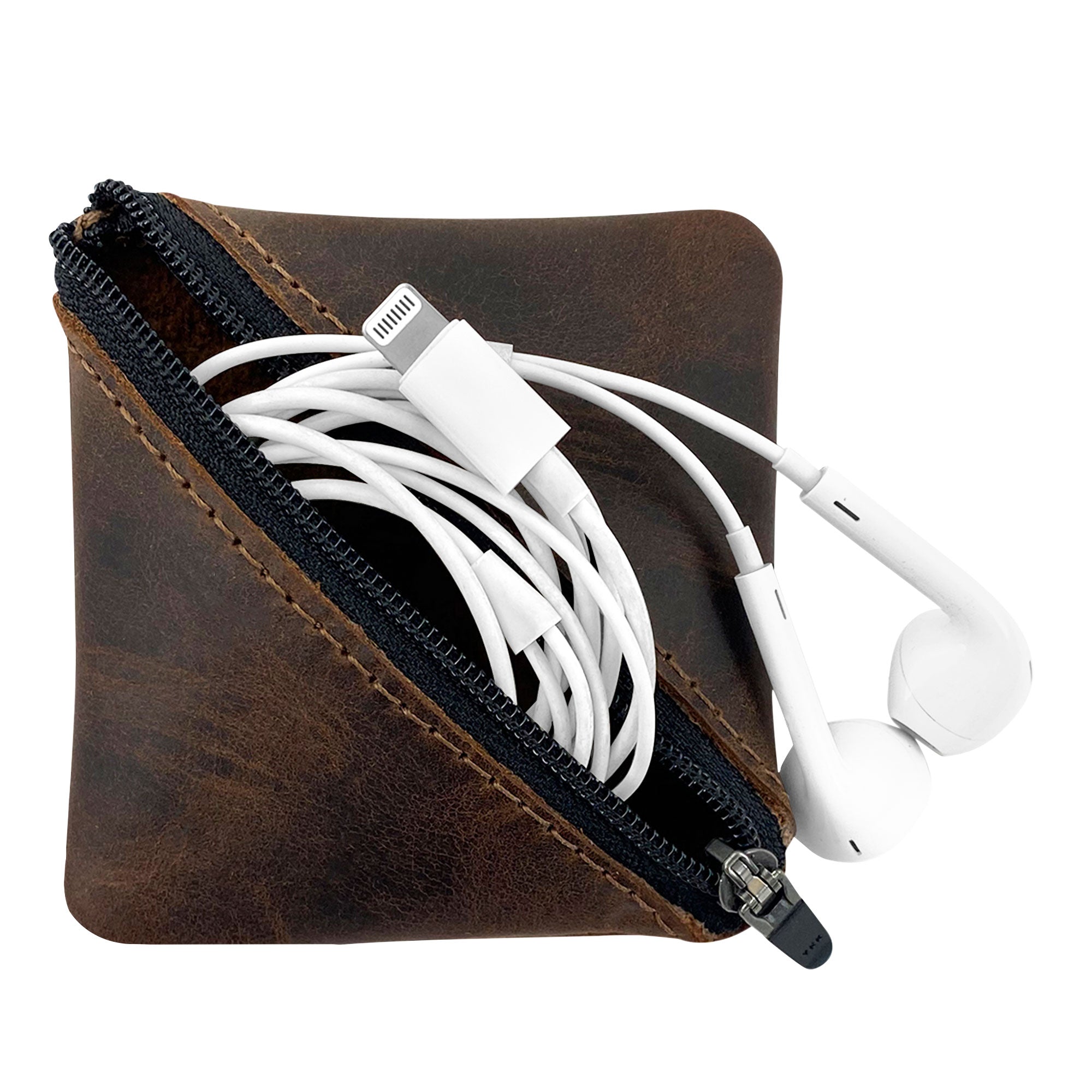 Open view of the Slash Zippered Pouch by Hide & Drink, displaying its use for storing earbuds and small tech accessories. This full grain leather pouch is perfect for organizing items in your pocket or purse, handcrafted by artisans in La Antigua Guatemala & Oaxaca Mexico.