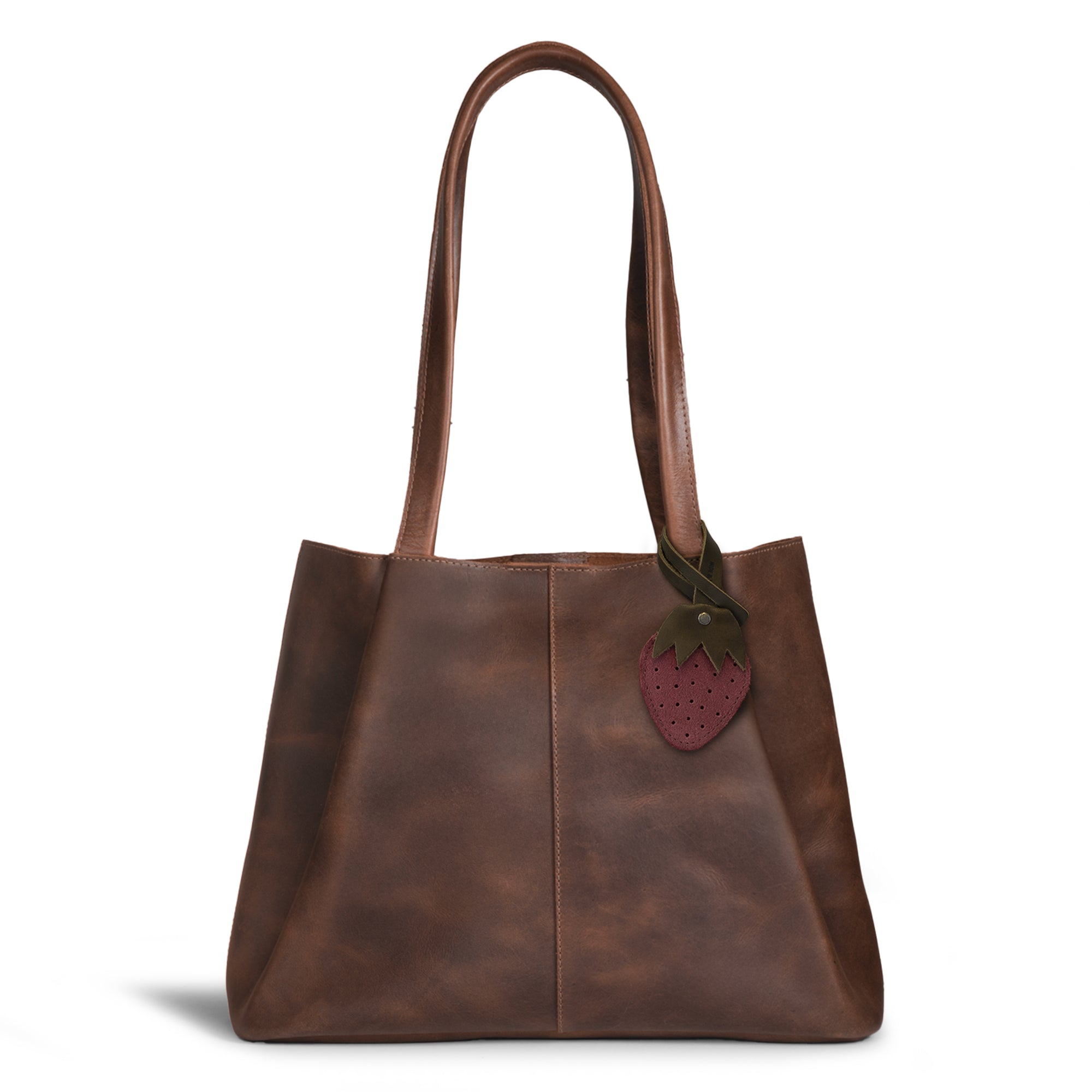 Hide & Drink Bag Charms attached to a stylish brown handbag, displaying a whimsical bat design ideal for personalization. This accessory serves as a purse charm for tote & backpacks made from high-quality full grain leather. Each piece exemplifies StockyardX's commitment to small batch production, showcasing hand cut, hand sewn artistry and fire branding, handmade in La Antigua Guatemala & Oaxaca Mexico.