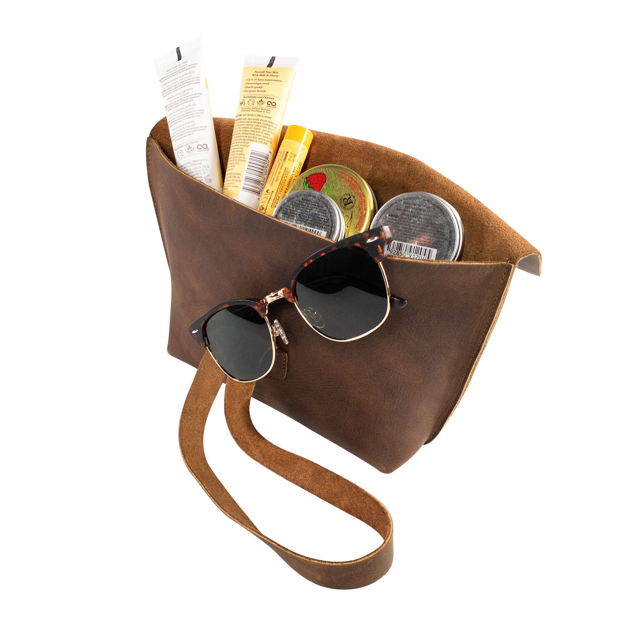 Open Women's Clutch Bag by Heather's, filled with essential items like sunglasses and cosmetics, illustrating its versatility as an accessories pouch. Crafted from Full Grain Leather, this artisan handbag is perfect for travel and everyday convenience.