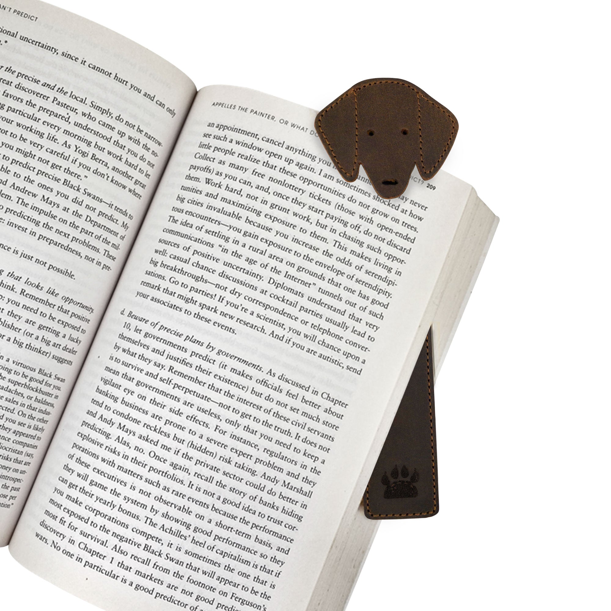 A Taco Dog Dog Bookmark in use, stylishly holding the page of an open book. This cute page marker, made from soft and durable full grain leather, is a functional accessory that makes a wonderful gift for dog and book lovers, created through artisan craftsmanship in La Antigua Guatemala.