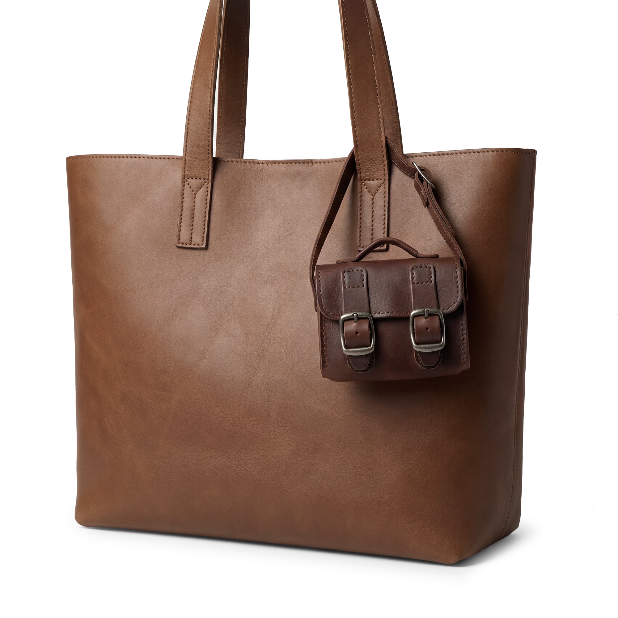 Side view of the Tiny Messenger Bag by Hide & Drink, highlighting the intricate details of this Mini Messenger Bag Charm made from Full Grain Leather. Designed to attach easily to handbags or as a keychain, it's a stylish artisan piece handmade in La Antigua Guatemala.