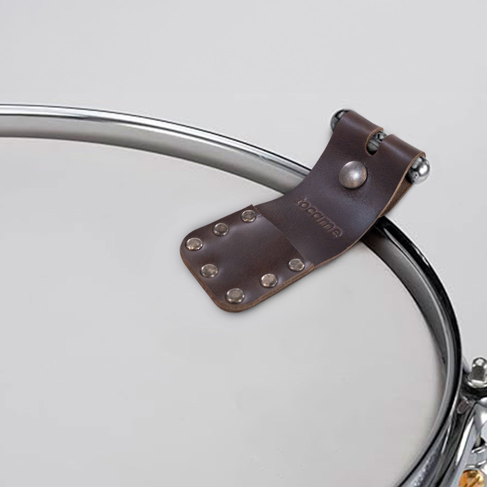 Set of 2 Flip Sleeves for Mute Drum Key Tool, Tuner & Dampener (Drum Key and Coin Not Included) by tocame, positioned on a drum rim for easy access. The stylish full grain leather offers durability, hand sewn craftsmanship, and a perfect solution for drummers needing quick access to their tools.