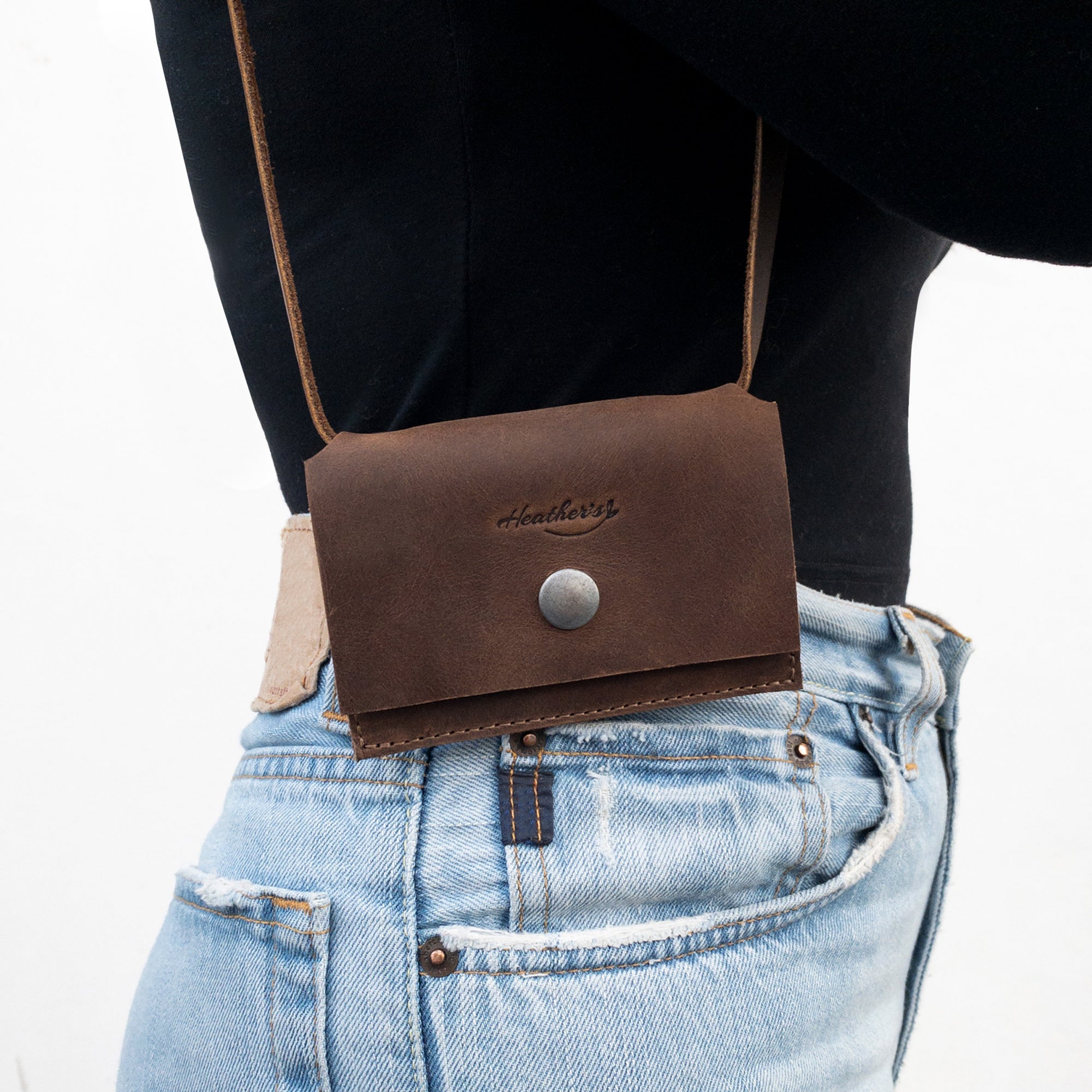 Heather's Mini Purse Wallet elegantly worn on a belt, highlighting its versatility as a Mini Wallet Purse with Strap. This sleek card holder also acts as a money organizer and ID storage, featuring high-quality full grain leather from small batch production, hand cut and sewn by artisans in La Antigua Guatemala.