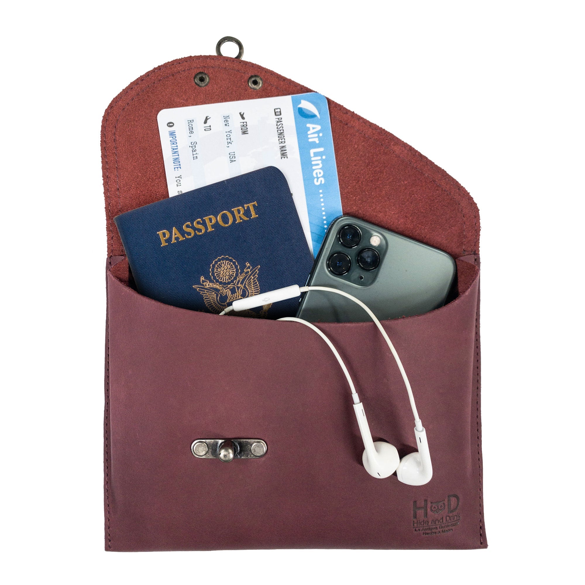 The Petite Vintage Clutch Bag by Hide & Drink filled with essentials like a passport and smartphone. This elegant evening bag combines function and style, crafted from premium full grain leather. A perfect travel accessory for those seeking handmade artisan products from small batch production in La Antigua Guatemala & Oaxaca Mexico.