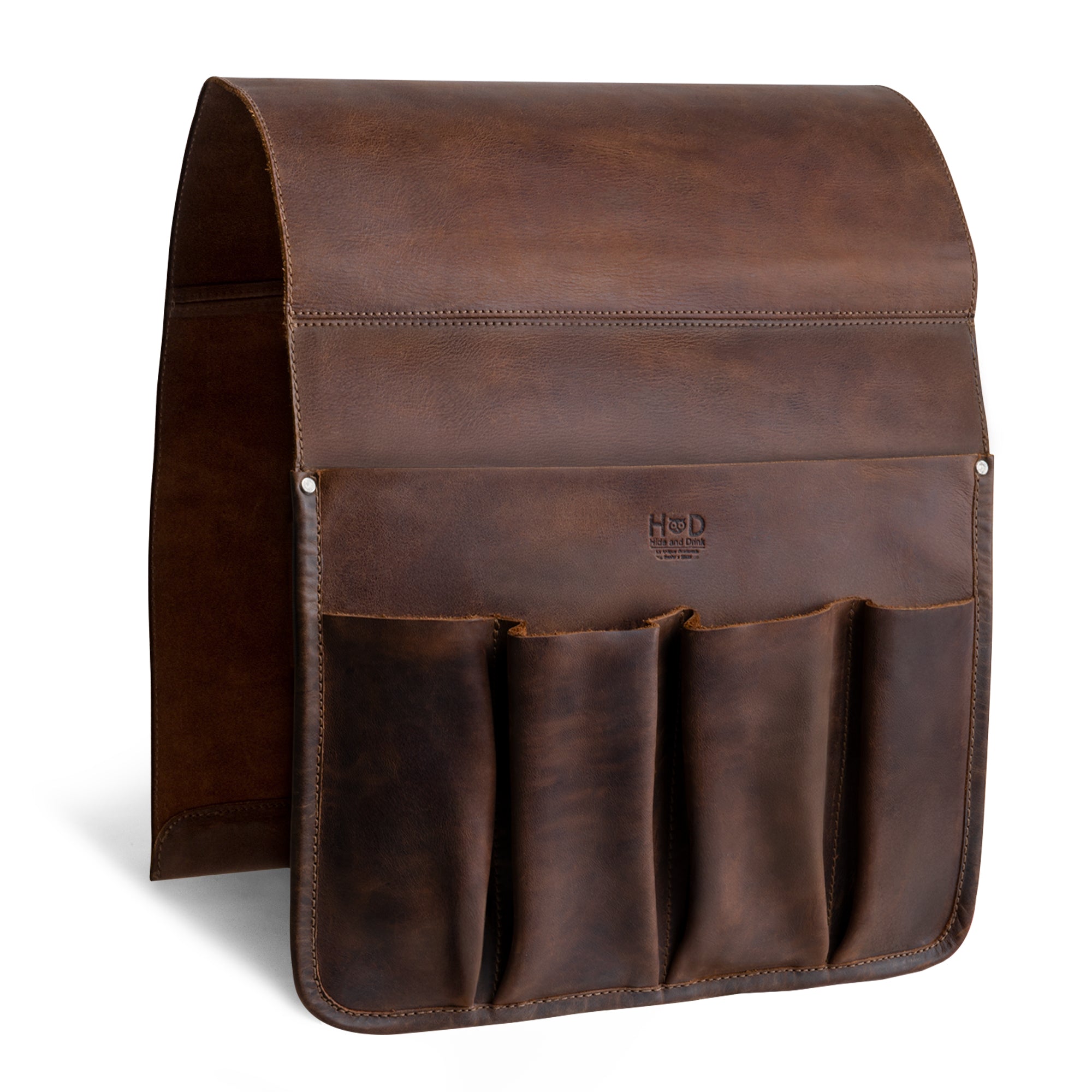 The sleek design of Hide & Drink’s Remote Control Holder displays its durable full grain leather, featuring spacious compartments for easy access to essentials like remotes and magazines. Perfect as an armchair caddy, this handmade item symbolizes small batch production expertise.