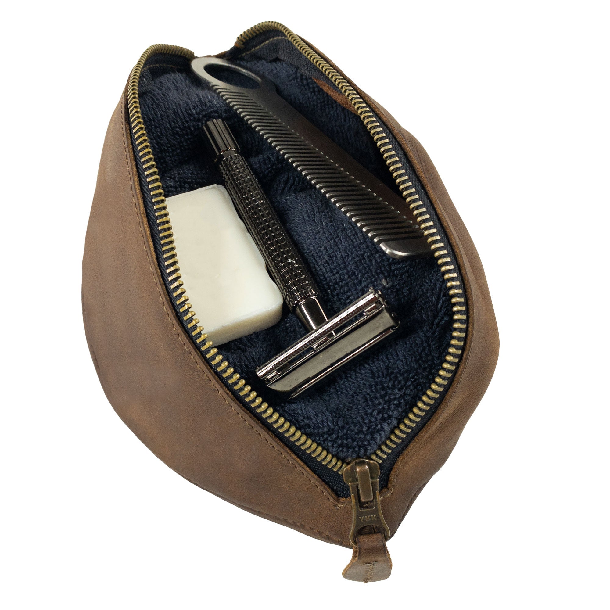 Inside view of the Football Toiletry Bag by Hide & Drink, featuring grooming tools neatly organized. This travel organizer is ideal for storing shaving kits and other essentials. Made from full grain leather, the Gameday Football Dopp Toiletry Bag reflects artisan craftsmanship from La Antigua Guatemala and Oaxaca Mexico, showcasing hand cut, hand sewn, and fire branded details.