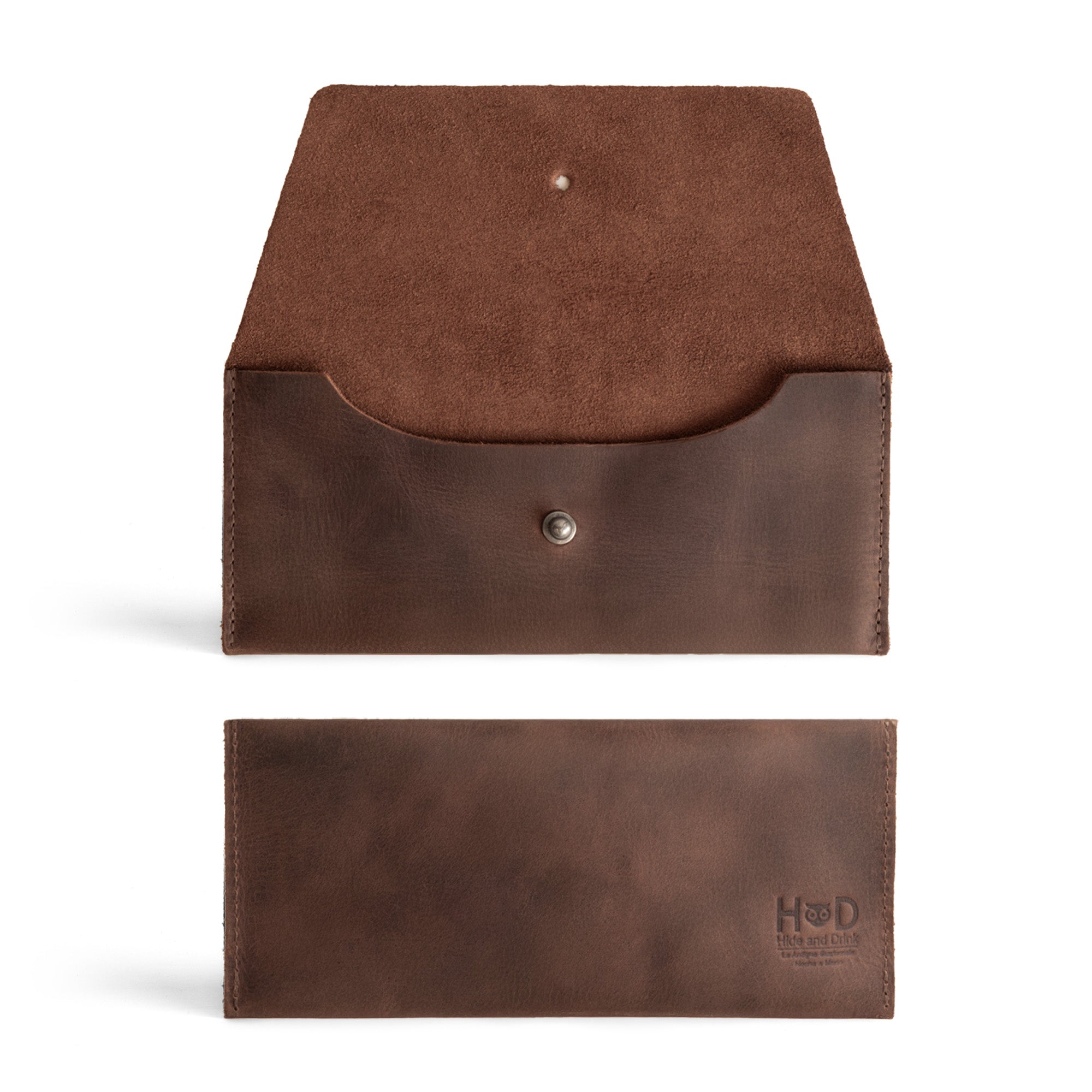 The Long Utility Pouch from Hide & Drink displayed with its sleek and minimalist design, emphasizing its handmade construction from full grain leather. A perfect stylish wallet for carrying and storing cash featuring a button closure.