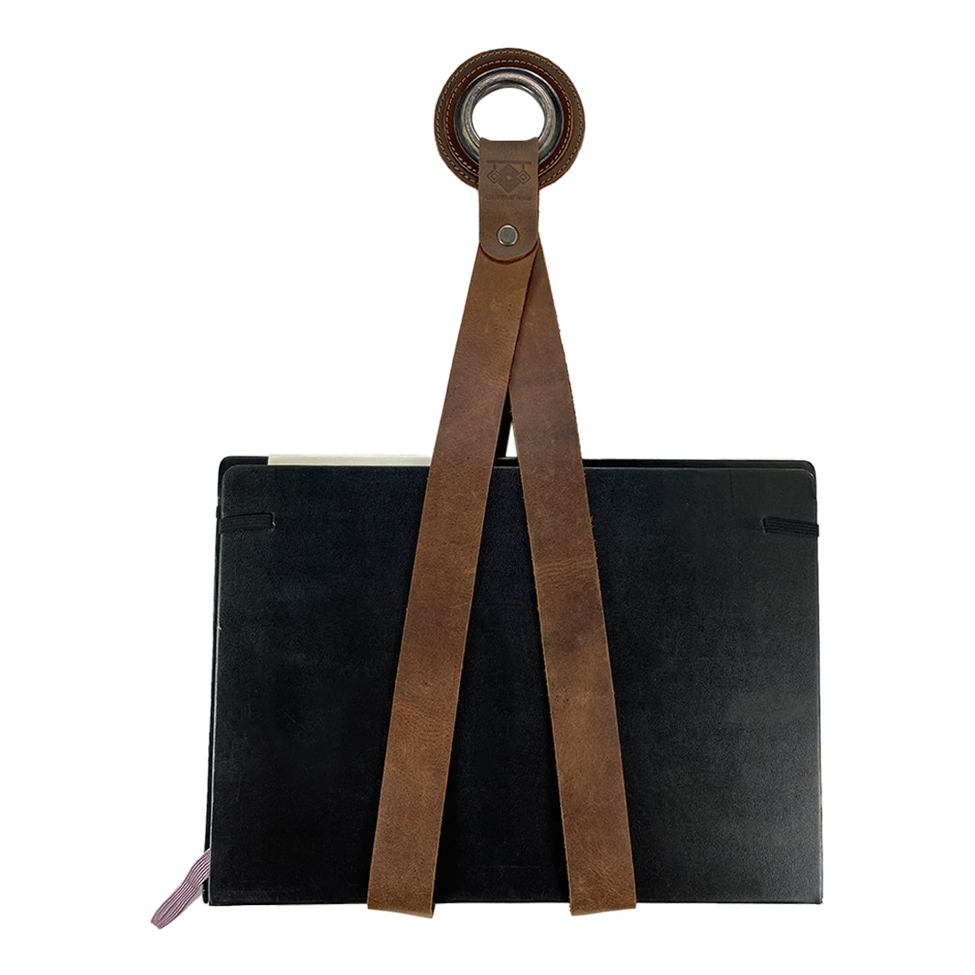 A stylish Book Wall Hanger made from full grain leather by Leather At Home, showcasing the rustic design ideal for organizing books, comics, and magazines. Perfect for readers, this handmade piece features small batch production, artisan craftsmanship, and is fire branded, emphasizing its uniqueness from La Antigua Guatemala & Oaxaca Mexico.