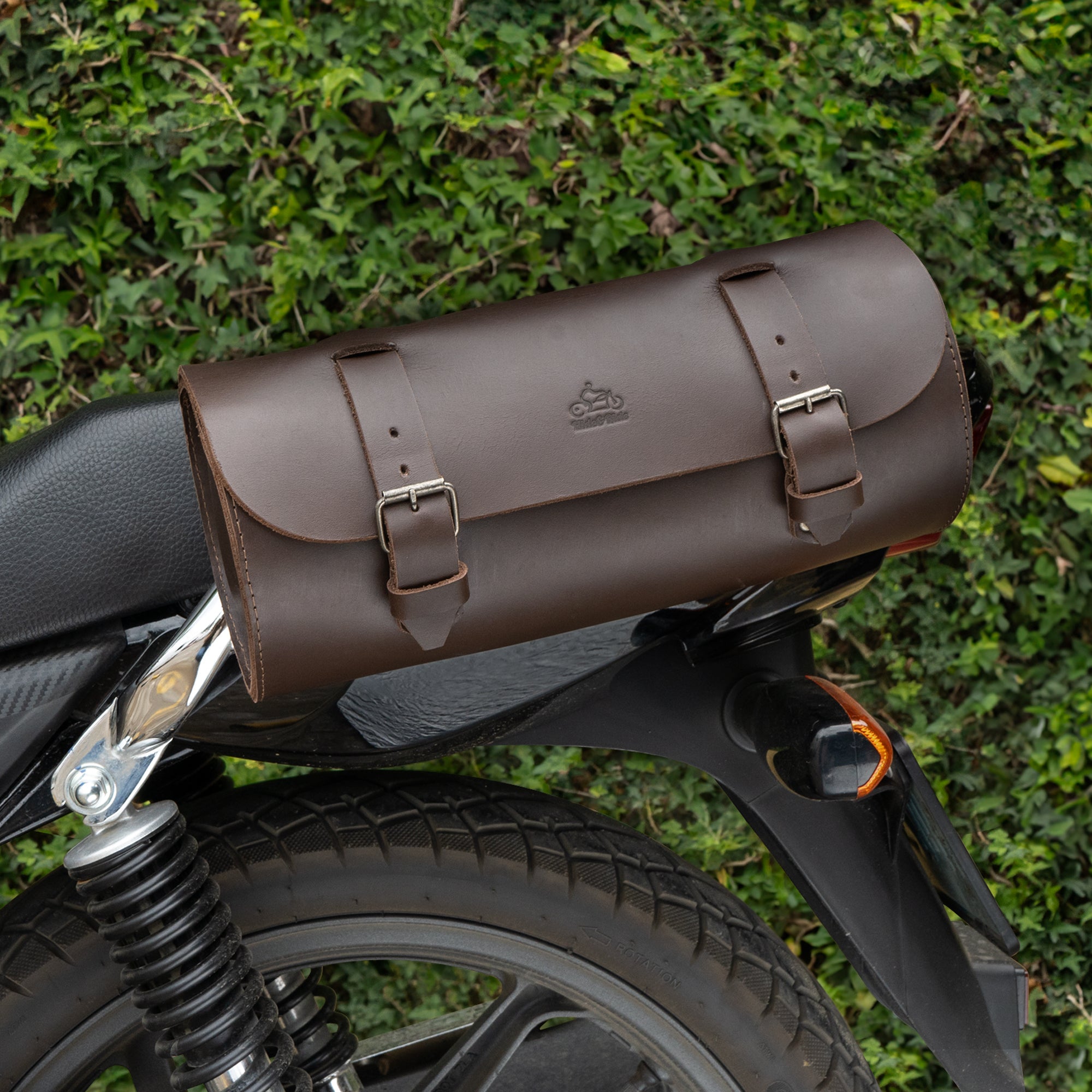 Cylinder Tool Roll for Motorcycle by Hide & Ride, shown attached to the side of a bike. This robust full grain leather roll is a perfect Circular Motorcycle Tool Bag and a versatile universal saddlebag for motorcycle riders. Artisan crafted in La Antigua Guatemala, it features a unique design for bikers.