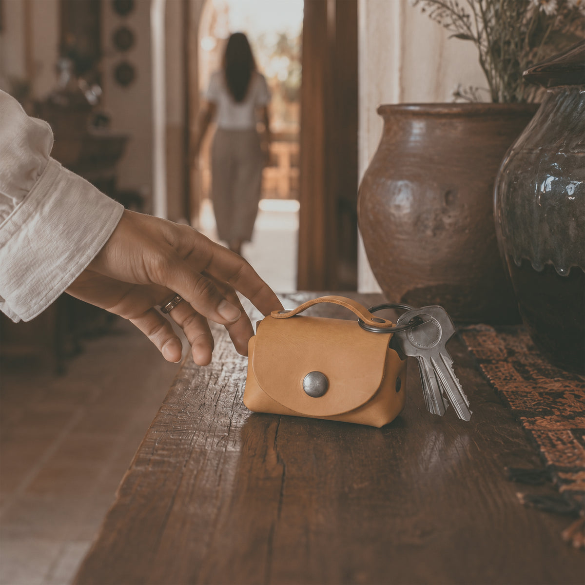Open view of the mustard Tiny Handbag Keychain by Hide & Drink, showcasing a Tiny Handbag with Key Ring Holder with coins inside, crafted from Full Grain Leather. This stylish accessory is part of Small Batch Production, Hand Cut, Hand Sewn, and Fire Branded, proudly made by artisans in La Antigua Guatemala & Oaxaca Mexico.