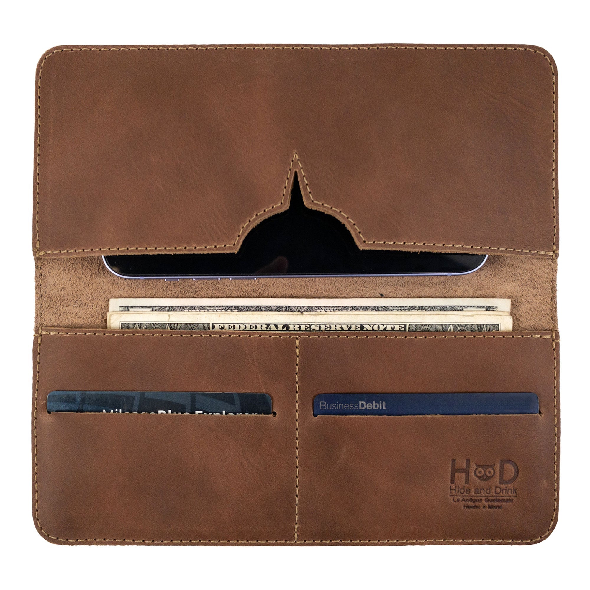 Closed view of the rustic bifold wallet for cellphone by Hide & Drink, focusing on its durable leather. This Bifold Wallet for Cellphone is a stylish accessory made from Full Grain Leather, perfect for daily essentials. Enjoy the artisan craftsmanship in this piece, made through small batch production in La Antigua Guatemala & Oaxaca Mexico.