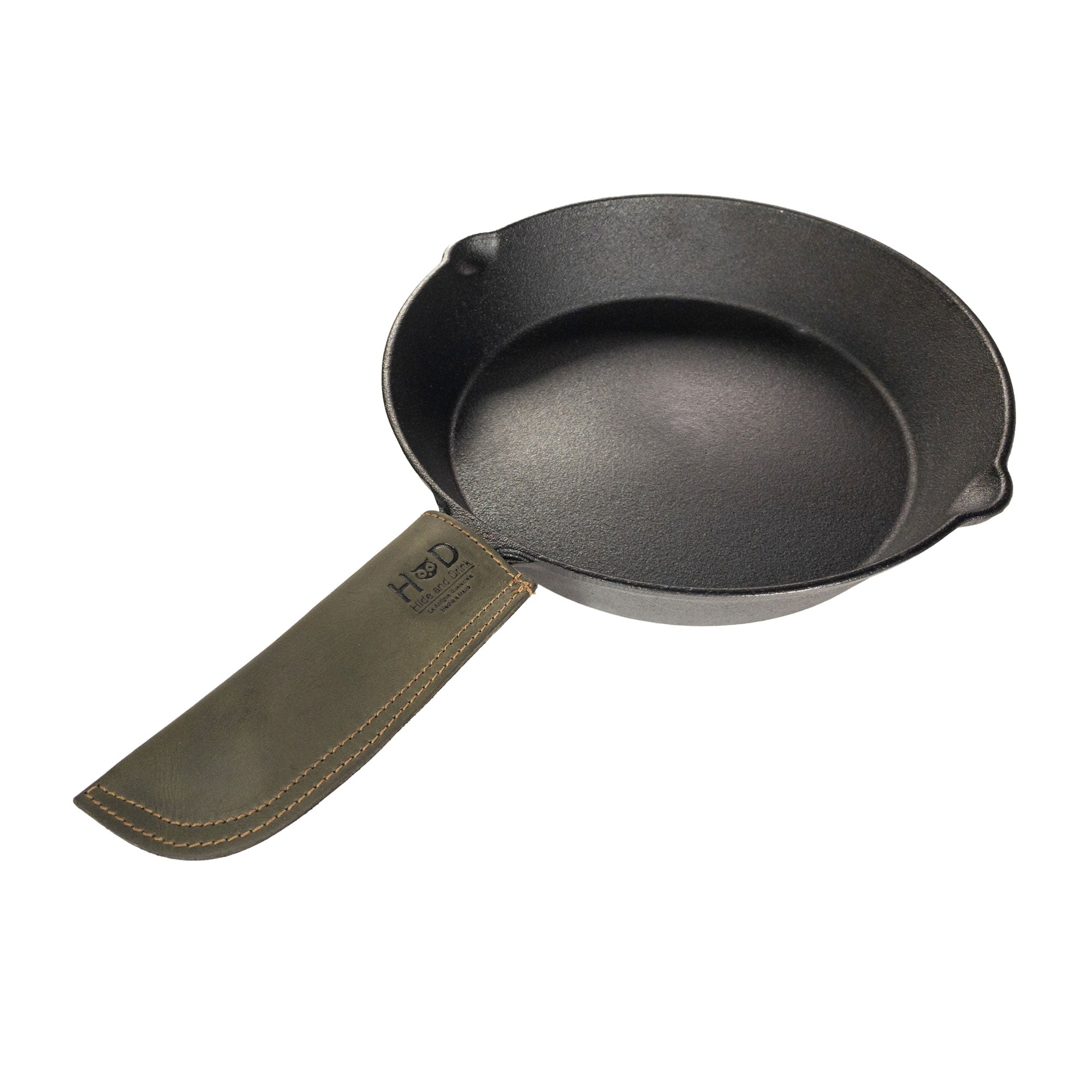 Hide & Drink Cast Iron Panhandle Cover elegantly displayed on a skillet, illustrating its practical features. This artisan hot handle protector is crafted with double stitched full grain leather for durability. Handmade in La Antigua Guatemala & Oaxaca Mexico, it's designed to elevate your cooking experience.