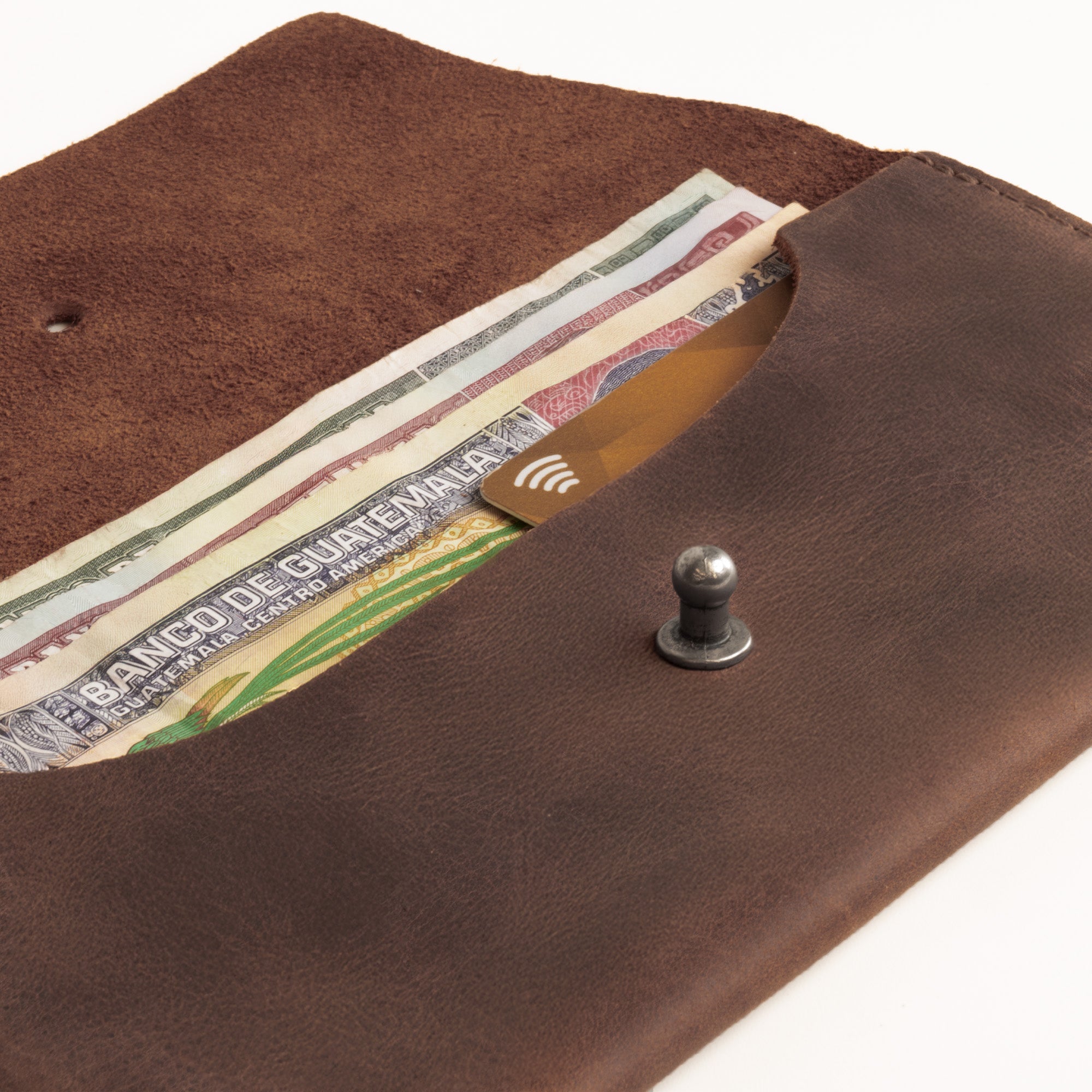 Close-up view of the Long Utility Pouch by Hide & Drink, highlighting the interior with cash and a card. This artisan-crafted wallet is designed for convenient storage, ensuring a stylish way to hold your essentials.
