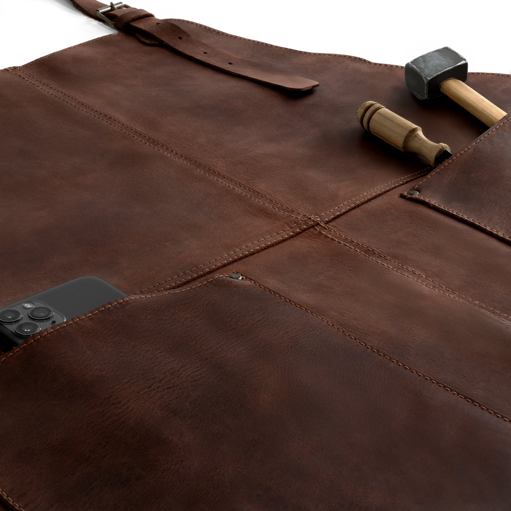 Close-up of the Hide & Drink Leather Apron highlighting its large pockets and tools, designed with durable full grain leather. This artisan-made Leather Apron offers comfort and functionality, perfect for a variety of tasks.