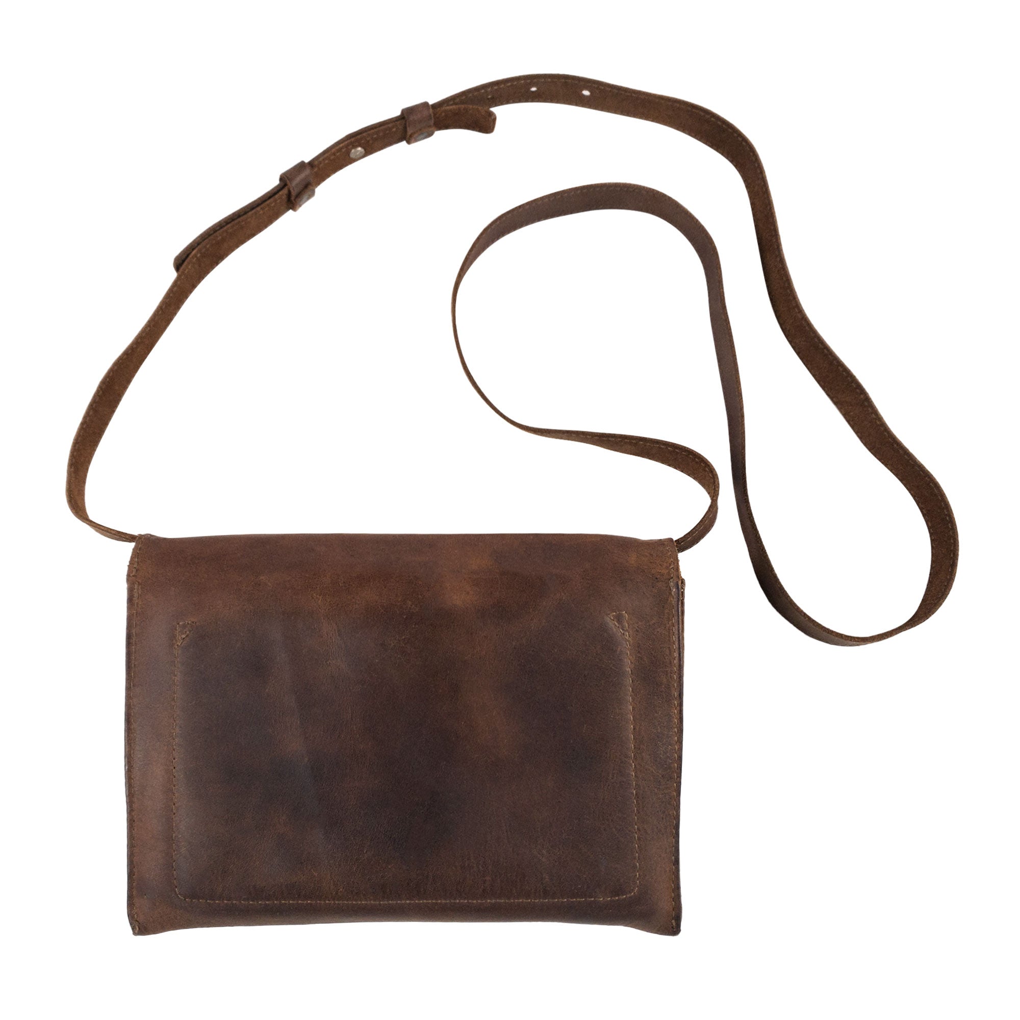 The back view of the Minimalist Shoulder Bag by Hide & Drink showcases its sleek profile made from durable full grain leather. This rectangular messenger bag, featuring an adjustable strap, serves as an ideal travel accessory. Celebrate the artisanal quality of this Mini Classic Shoulder Bag, which is hand cut, hand sewn, and fire branded, reflecting craftsmanship from La Antigua Guatemala & Oaxaca Mexico.