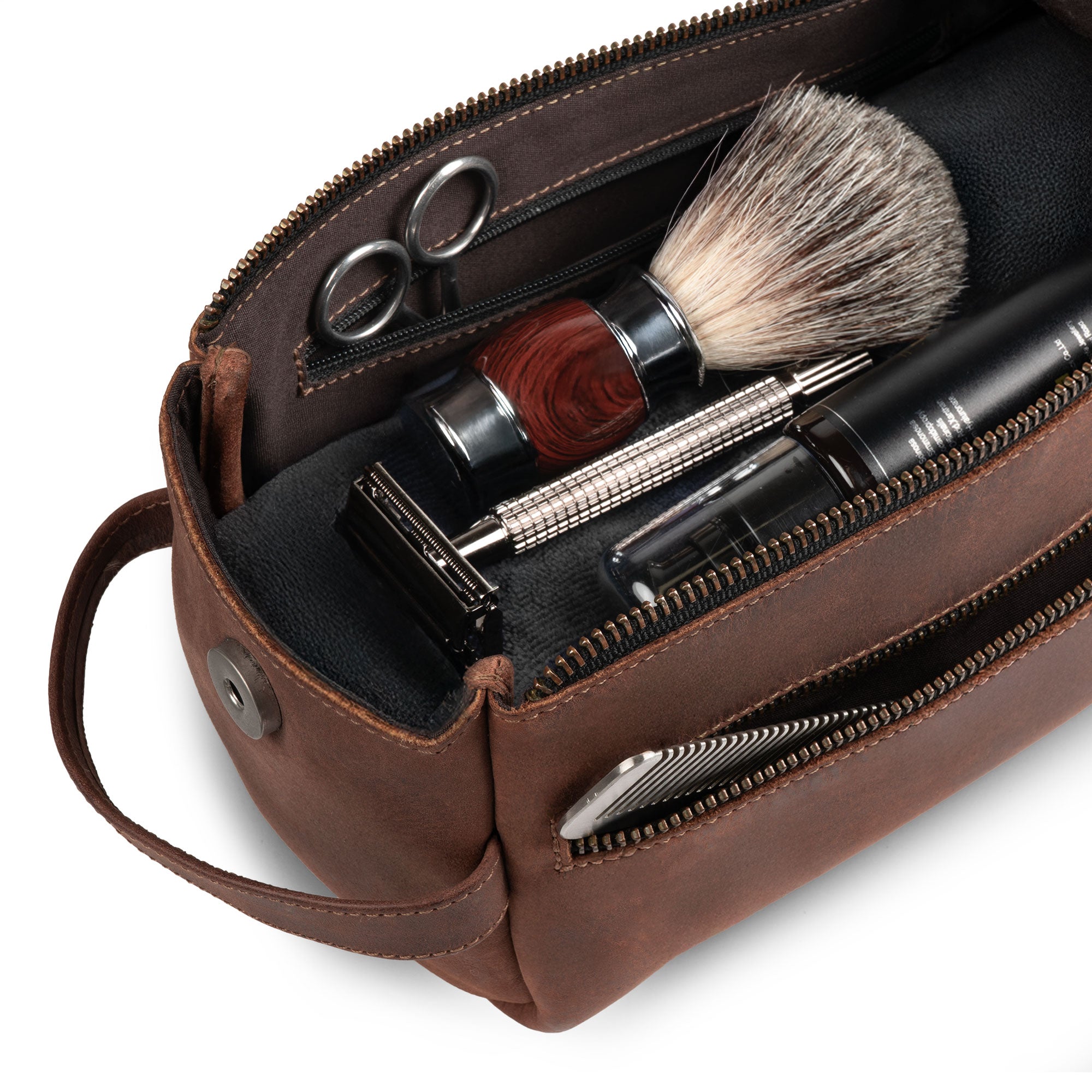Hide & Drink's Toiletry Bag's interior featuring grooming essentials. This Full Grain Leather Toiletry Bag doubles as a Hand Bag and a Dopp Kit Organizer for convenient travel. StockyardX, Handmade, S.