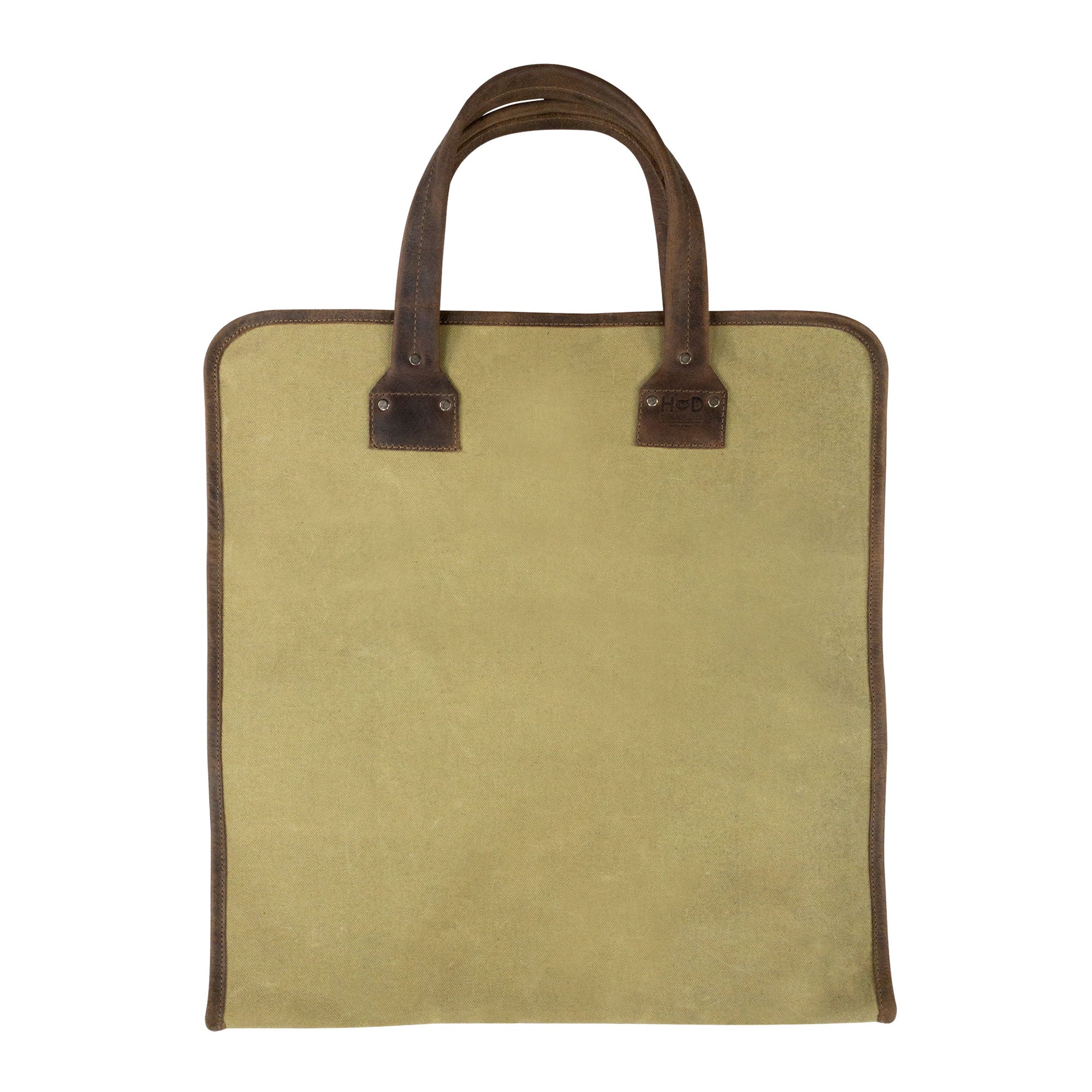 Hide & Drink Firewood Bag resting on wood, featuring durable design elements and a classic look that enhance any outdoor or indoor setting. Firewood Bag With Leather Liner, Full Grain Leather, StockyardX, Small Batch Production, Hand Cut, Hand Sewn, Fire Branded, Artisan, Handmade in La Antigua Guatemala & Oaxaca Mexico.