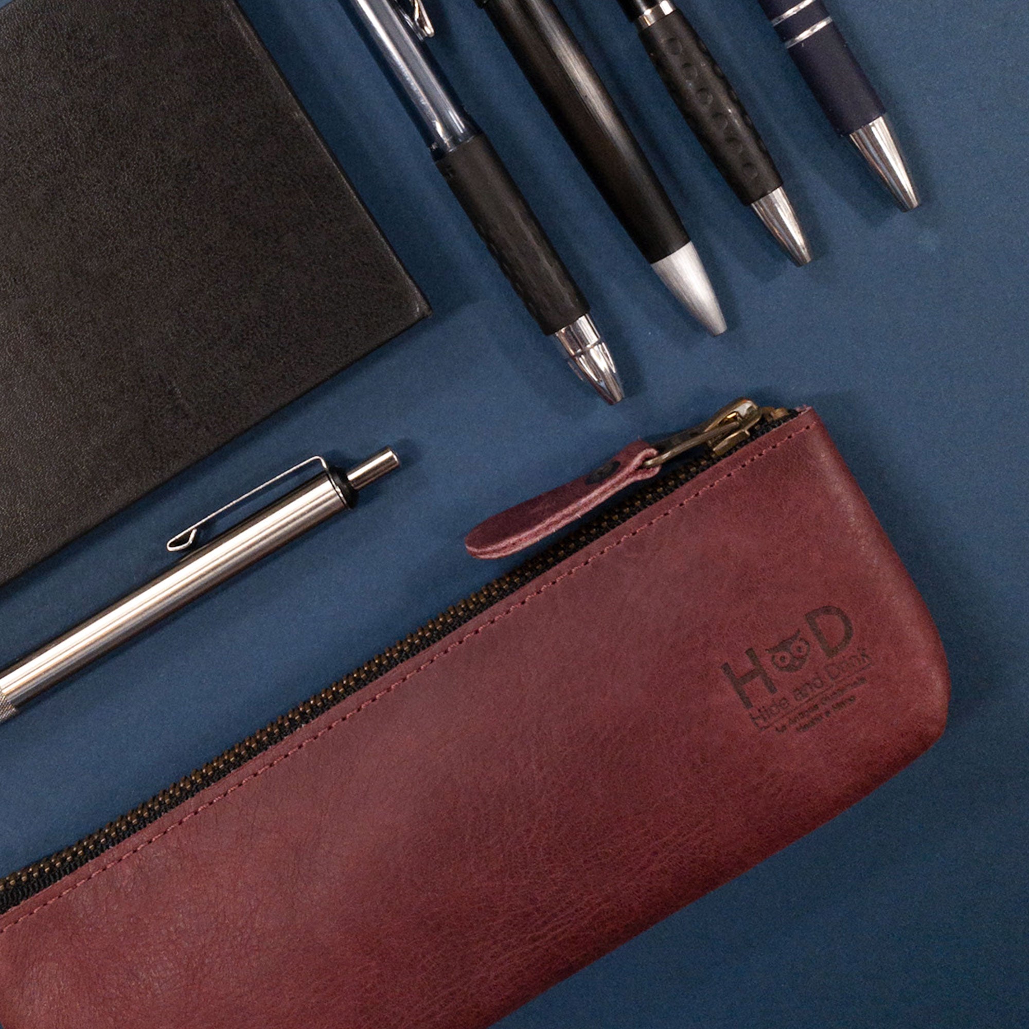 Pencil Pouch by Hide & Drink in burgundy leather, open to reveal the inner lining. This flat zippered holder is a trendy Rectangular Pencil Case, perfect for artists and crafted with care in small batches in La Antigua Guatemala.