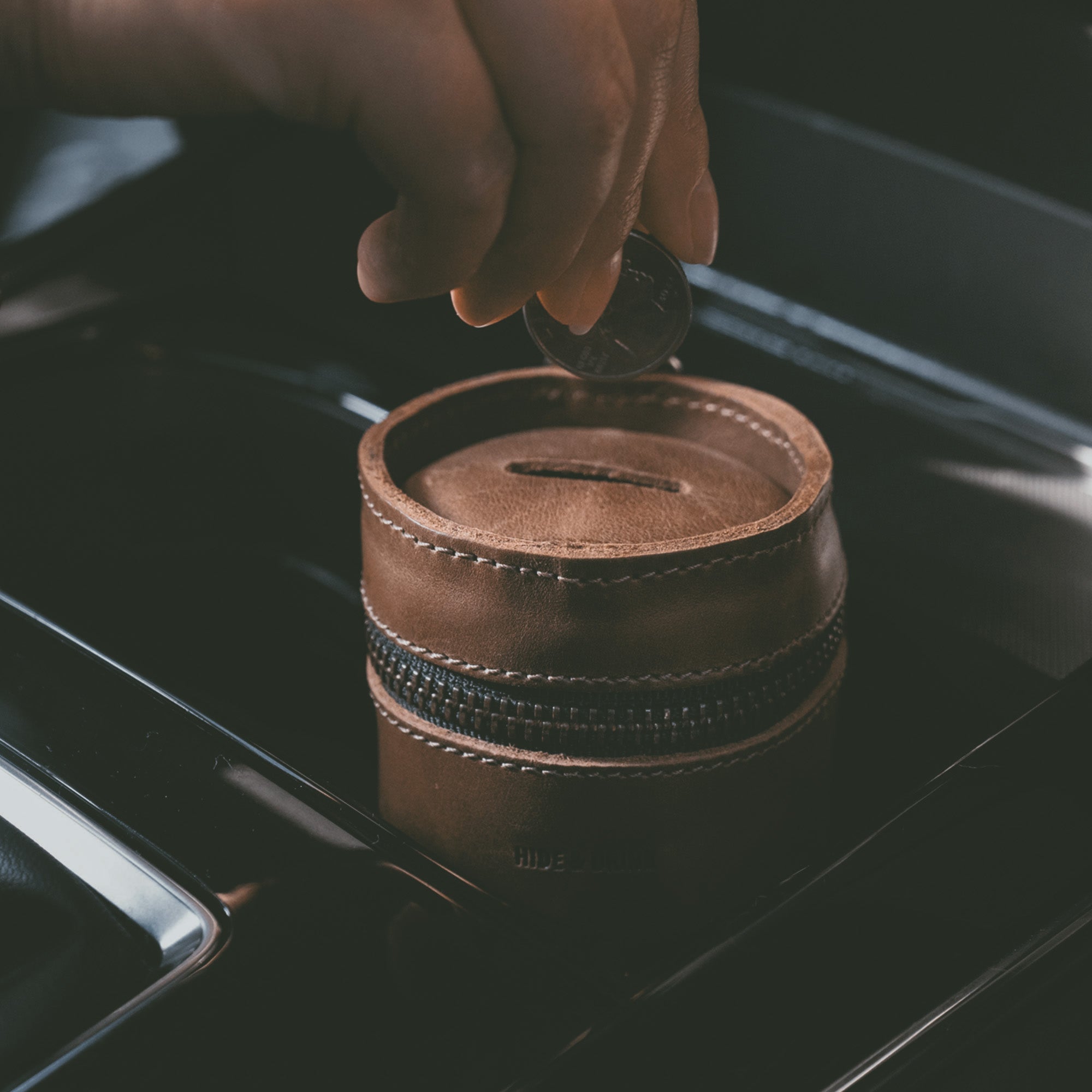 User inserting a coin into Hide & Drink's Bucket Coin Release coin pouch, showcasing its functional design as a cash holder organizer. This artisan-made money saving box combines elegance with utility, perfect for little treasures for men and women.