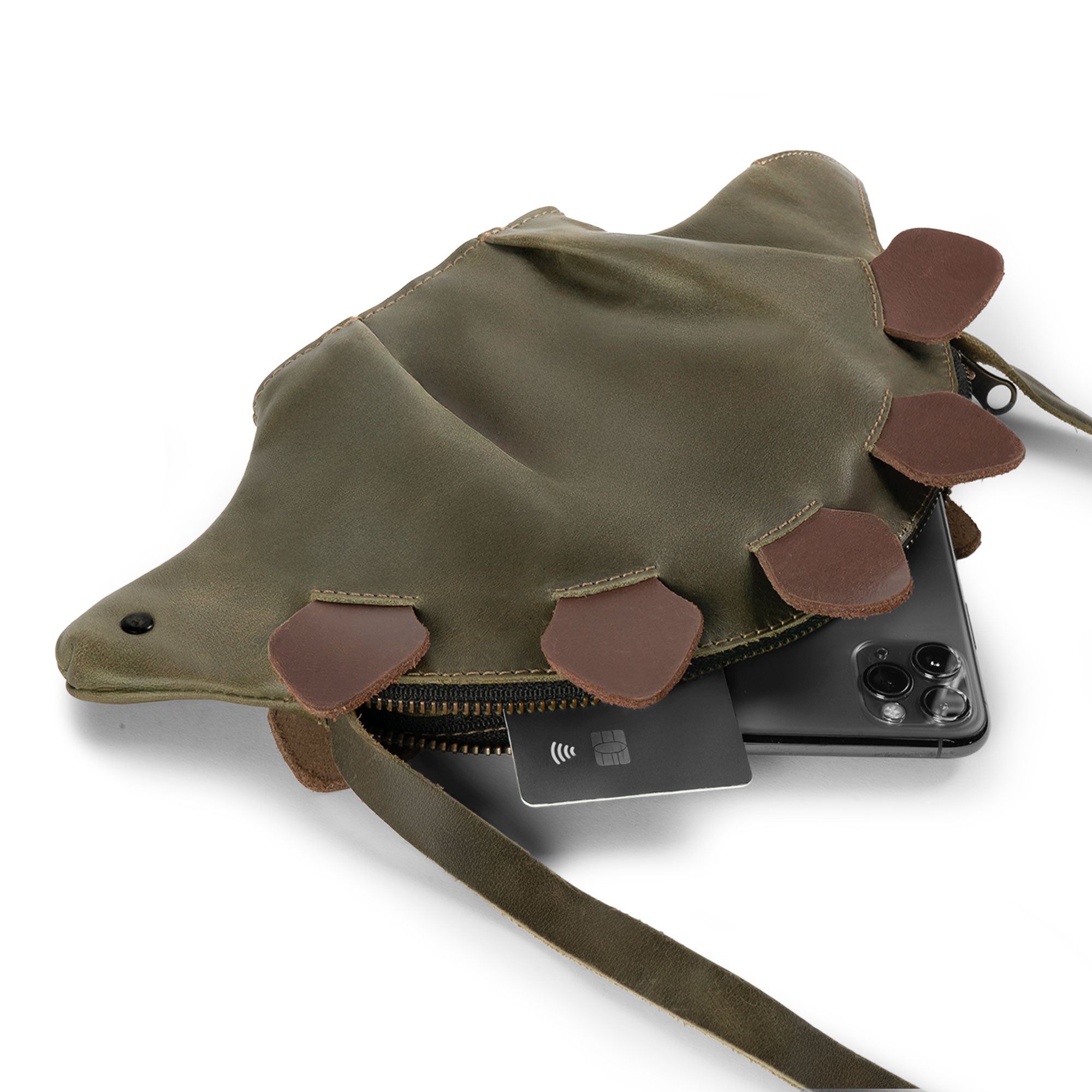 Dinosaur-Shaped (Stegosaurus) Shoulder Bag by Tudi Frudi displaying its capacity with essentials inside, highlighting its versatility as a Crossbody Bag made from Full Grain Leather. Perfect for daily use, this Artisan piece is Hand Cut, Hand Sewn, and Fire Branded.