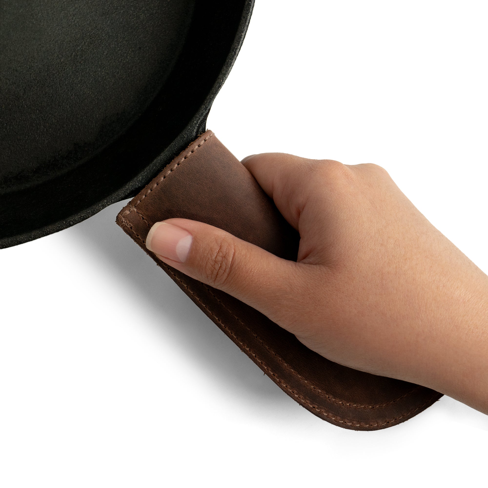 Hide & Drink Cast Iron Panhandle Cover elegantly modeled in a hand-held grip. This artisan piece combines aesthetics and utility as a hot handle protector, sporting a double stitched design for durability. Handmade in La Antigua Guatemala & Oaxaca Mexico, it enhances any kitchen with its unique flair.