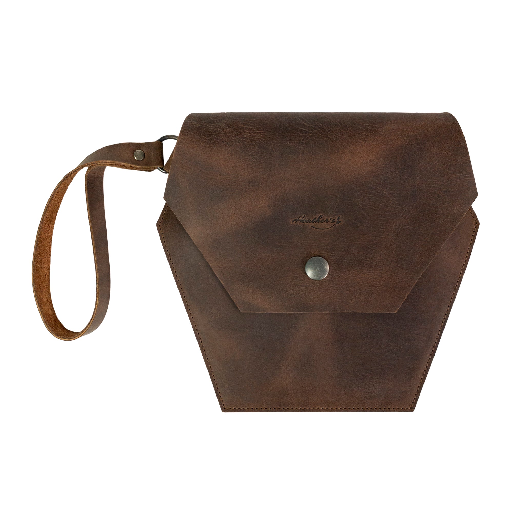 Hexagonal Clutch Bag in rich brown leather by Heather's, featuring a wristlet strap for hands-free convenience. Perfect for travel, this handbag is ideal for carrying makeup and toiletry items. Crafted from Full Grain Leather, each piece represents small batch production and is hand cut, hand sewn, fire branded, and artisan made in La Antigua Guatemala & Oaxaca Mexico.