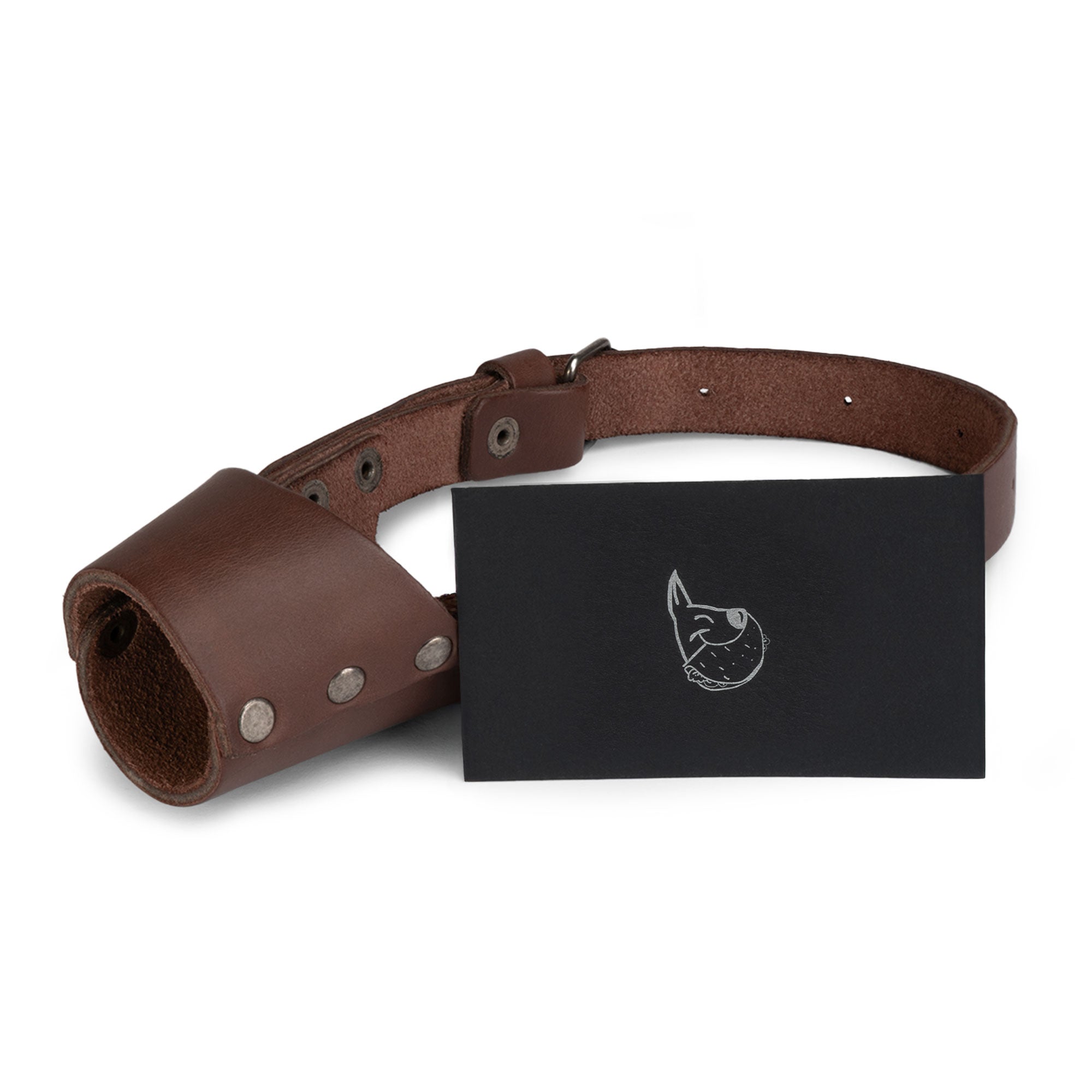Taco Dog Dog Muzzle with a business card, showcasing the quality that goes into this handmade product. Made from full grain leather, this Dog Muzzle serves as a secure training cover and mouth guard mask, crafted by artisans in La Antigua Guatemala.