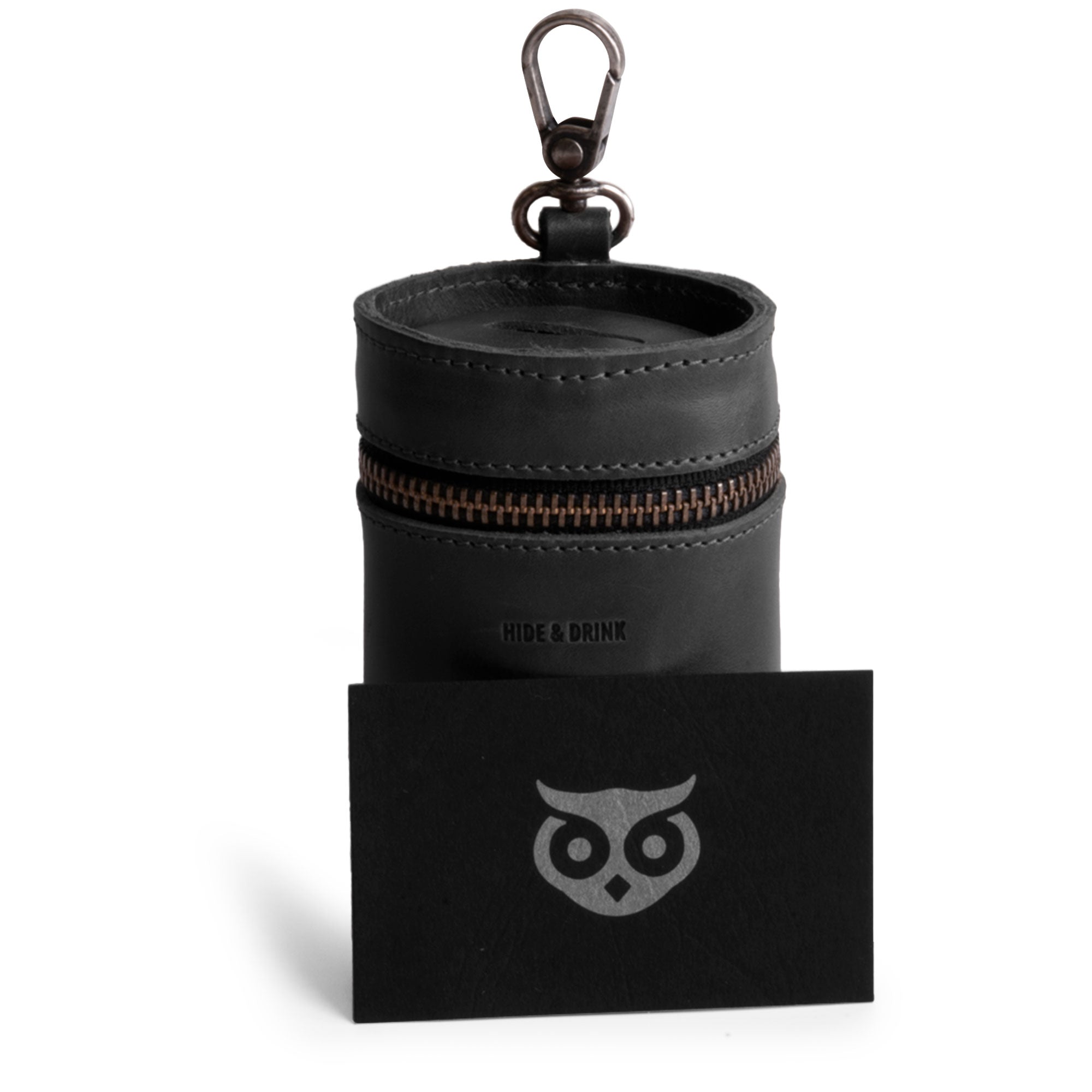 Hide & Drink's black Bucket Coin Release alongside a branding card, emphasizing its artisan touch. This zippered coin pouch acts as an elegant cash holder organizer, crafted with premium full grain leather.