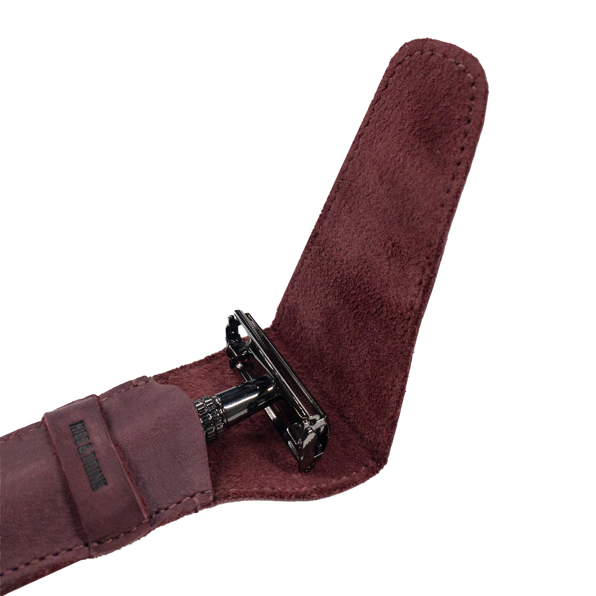 An interior view of Hide & Drink's burgundy Safety Razor Case that showcases its craftsmanship and snug fit around a razor. This stylish personal care accessory is handmade from Full Grain Leather, featuring the artisan quality synonymous with small batch production.